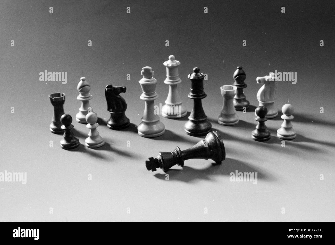 Chess Pieces., Whizgle News, Dutch Desk, Niederlande, 1950 - 2000. Diese Themen werden in der Abbildung angezeigt. Die Szene zeigt eine Sammlung von Schachstücken, die dynamisch und dennoch chaotisch auf einer glatten Oberfläche angeordnet sind. Die Stücke sind überwiegend weiß und schwarz und zeigen einen klassischen Kontrast. Mehrere Figuren stehen aufrecht, darunter Ritter, Bäche, Bischöfe und Bauern. jedes Detail mit unterschiedlichen Formen und Größen, die ihre einzigartige Rolle im Spiel widerspiegeln. Die Beleuchtung ist weich und gestreut und erzeugt sanfte Schatten, die der Szene Tiefe und Dimension verleihen. Der Hintergrund ist Stockfoto