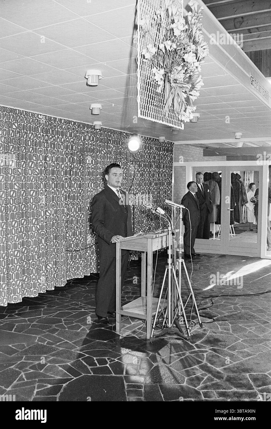 Eröffnung durch Minister Marijnen Keukenhof Stiftung Nachlass in Lisse, Whizgle News, Dutch Desk, Niederlande, 1950 - 2000 am 28.03.1963. Diese Themen werden in der Abbildung angezeigt. Die Szene entfaltet sich in einem geräumigen Innenbereich, der sich durch moderne architektonische Linien und einen polierten Steinboden auszeichnet. Im Vordergrund steht ein Mann selbstbewusst hinter einem hölzernen Podium, das von mehreren Mikrofonen flankiert wird. Er trägt einen formellen Anzug, steht gerade mit einem ernsten Ausdruck, was darauf hindeutet, dass er kurz davor ist, ein Publikum zu sprechen. Hinter ihm sorgt eine komplizierte, gemusterte Kulisse für visuelles Interesse. Die des Stockfoto