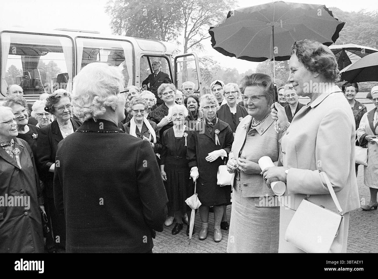 Königliche Empfänge und königliche Besuche Baarn Amsterdamsestraatweg 1, Whizgle News, Dutch Desk, Niederlande, 1950 - 2000 am 18-06-1968. Dies sind die Elemente im Bild. In einer lebhaften Umgebung im Freien versammeln sich eine große Gruppe von Frauen, die alle stilvolle Outfits tragen, die typisch für eine frühere Ära sind, mit einer Mischung aus Kleidern und maßgeschneiderten Anzügen. Die Frauen zeigen unterschiedliche Frisuren, von eleganten Hochsteckfrisuren bis hin zu lockeren Locken, die ein Gefühl von Gemeinschaft und Kameradschaft widerspiegeln. An der Spitze stehen einige Frauen in Gesprächen, die Wärme und Lächeln ausstrahlen. Eine Frau hält Stockfoto