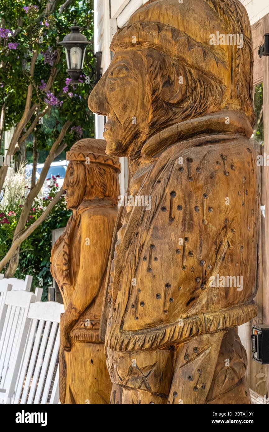 Indische Holzskulpturen vor den Watkins Outfitters liegen im Village at Indian Springs neben dem Indian Springs State Park in Flovilla, Georgia. Stockfoto