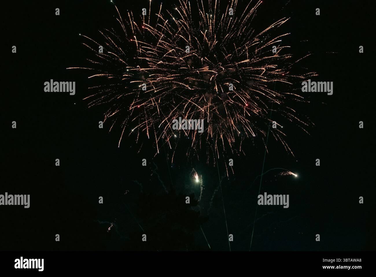 Ein großes Feuerwerk erleuchtet den Nachthimmel und erfüllt ihn mit leuchtenden Farben und einem festlichen Leuchten. Stockfoto