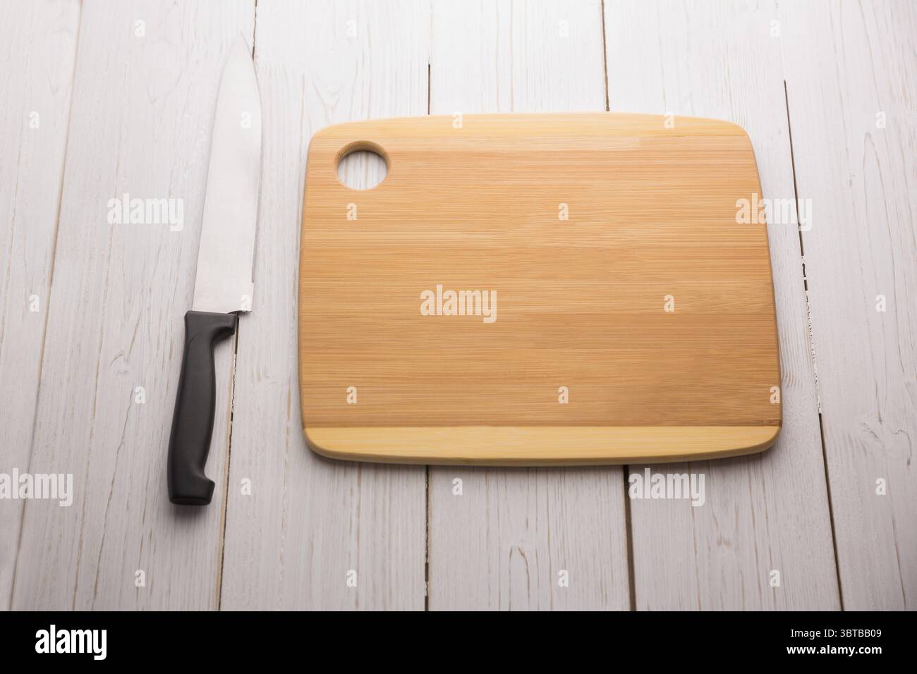Küchenmesser und Schneidebrett auf Holzboden Stockfoto