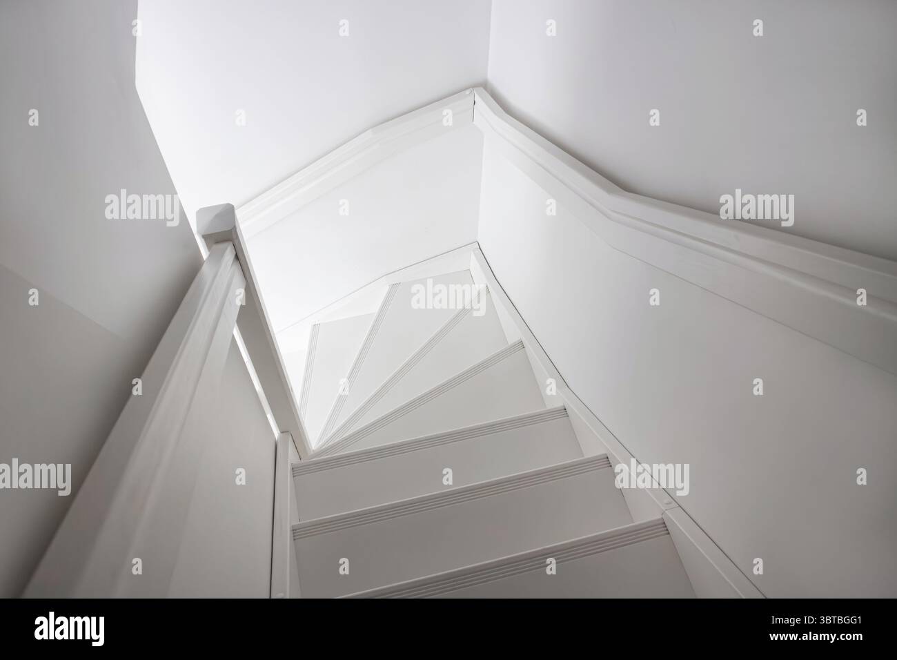 Weiß lackierte Holztreppe mit einer Ecke. Skandinavisches Wohnkultur-Konzept. Stockfoto