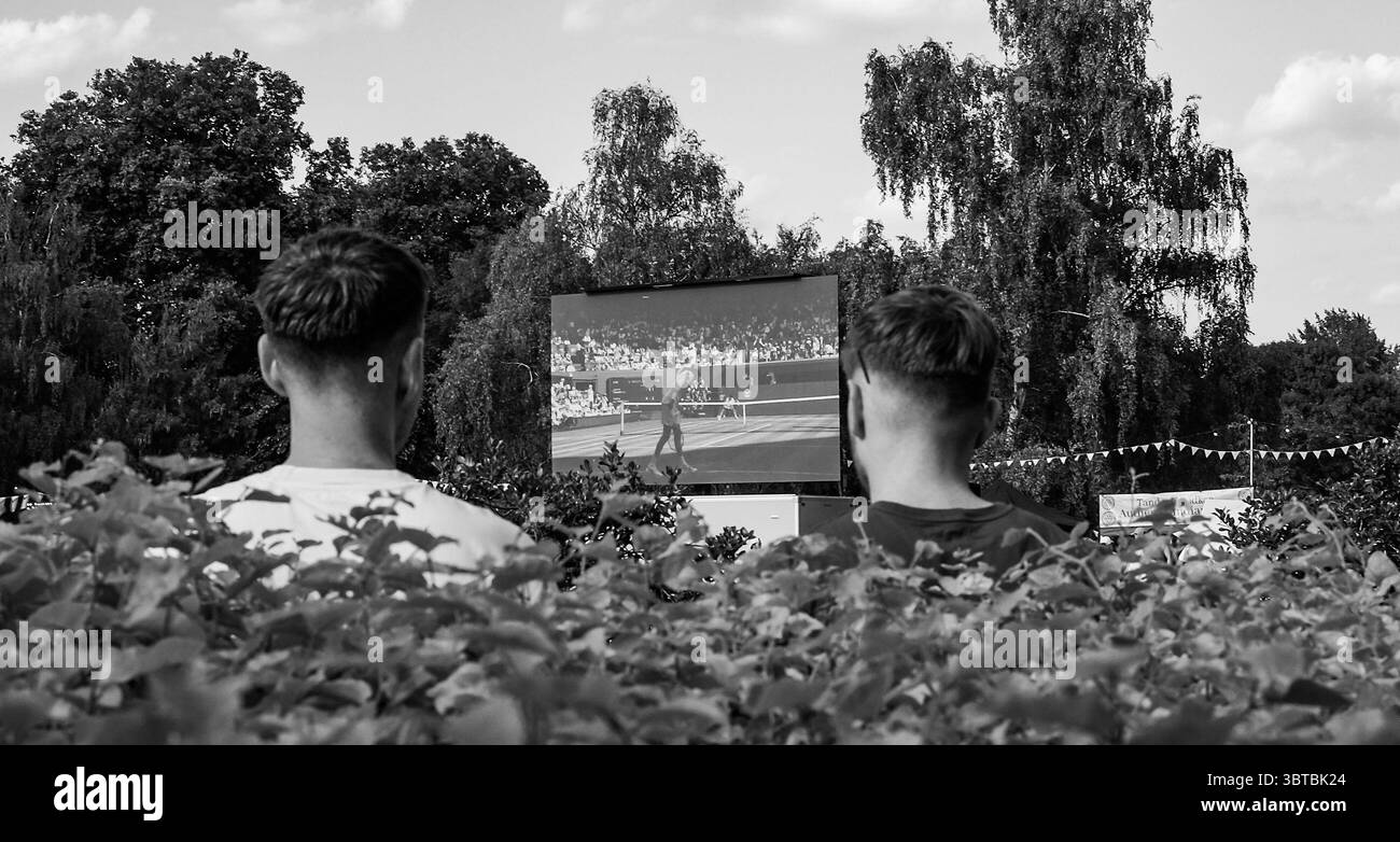Zuschauer sehen das Wimbledon Mens Tennis Final zwischen Jannik Sinner und Carlos Alcaraz auf einer Großleinwand im Battersea Park bei heißem Sonnenschein am 13. Juli 2025 in London Stockfoto