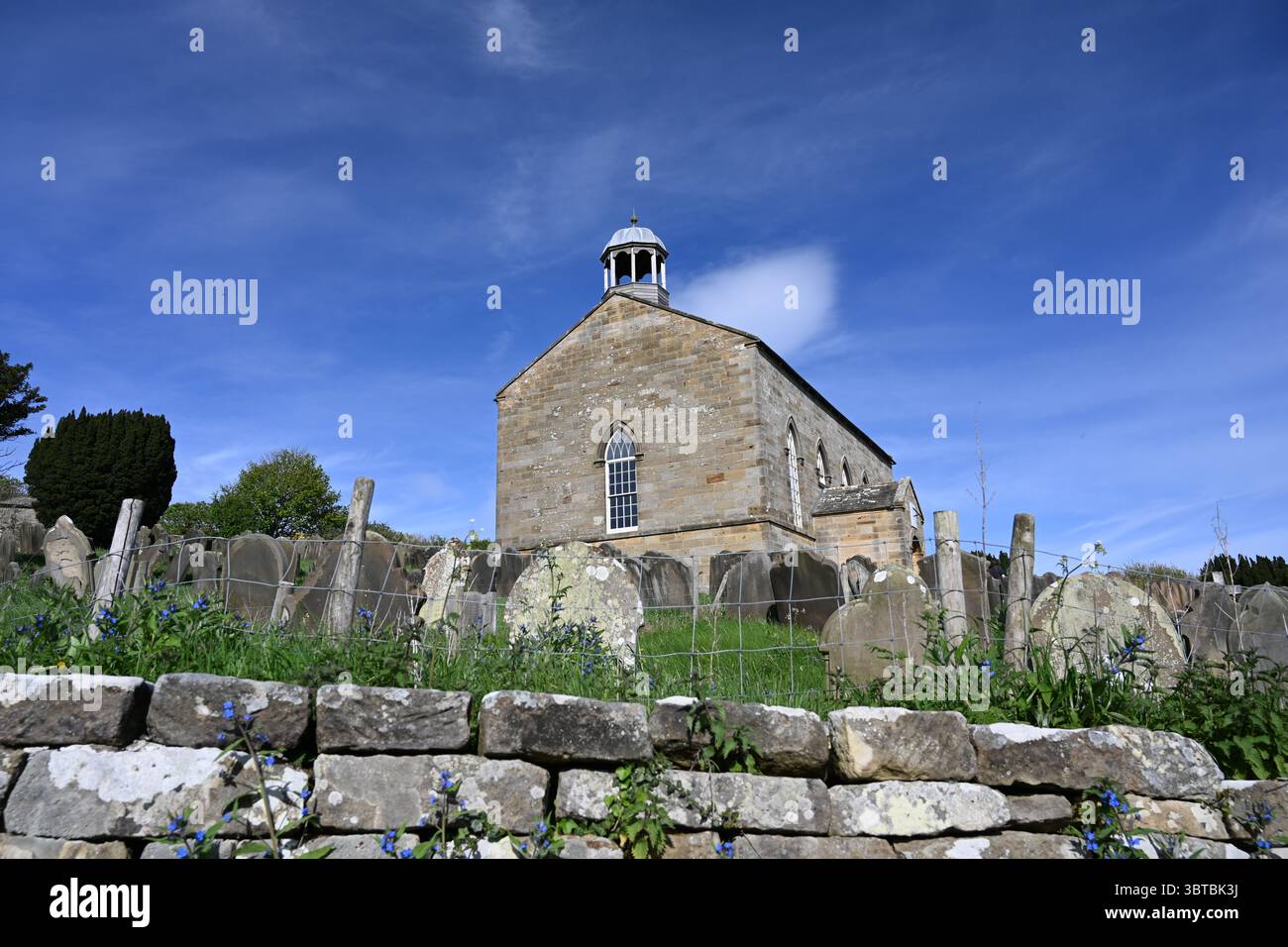 Historischer Friedhof der alten St. Stephans Kirche. Stillgelegte anglikanische Kirche in Fylingdales mit Blick auf Robin Hood's Bay, North Yorkshire. Stockfoto