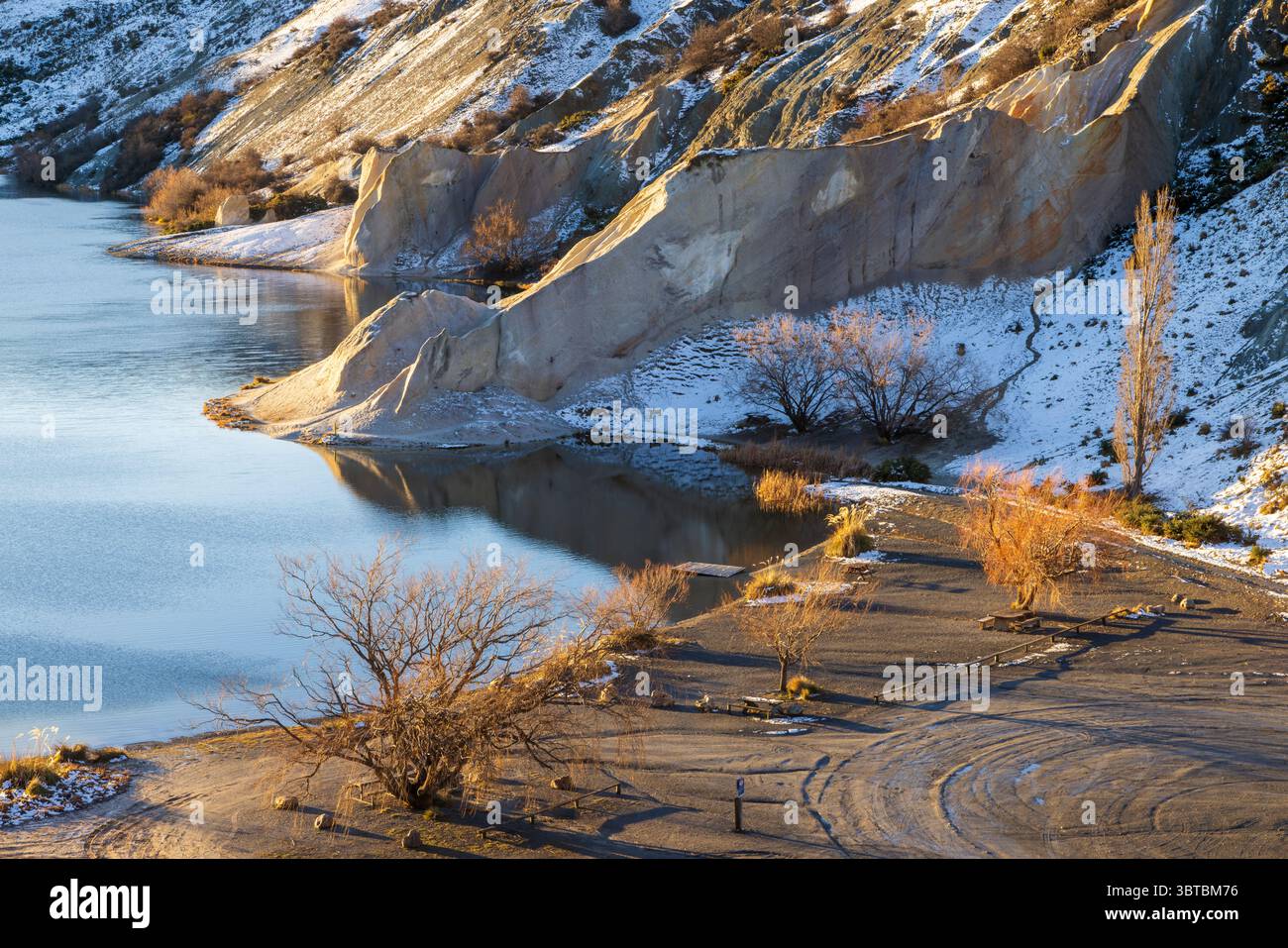 Der Blue Lake in St. Bathans, Neuseeland. Blick auf die Küste, umgeben von Quarzgranitklippen, im Winter Stockfoto