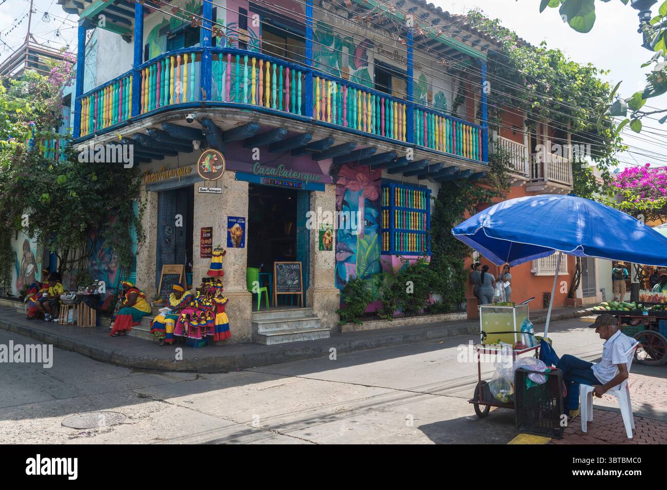 Straßenszene der Plaza de la Trinidad mit farbenfrohen Häusern, Palenqueras und Straßenverkäufern im Getsemani-Viertel, Cartagena, Kolumbien. Stockfoto