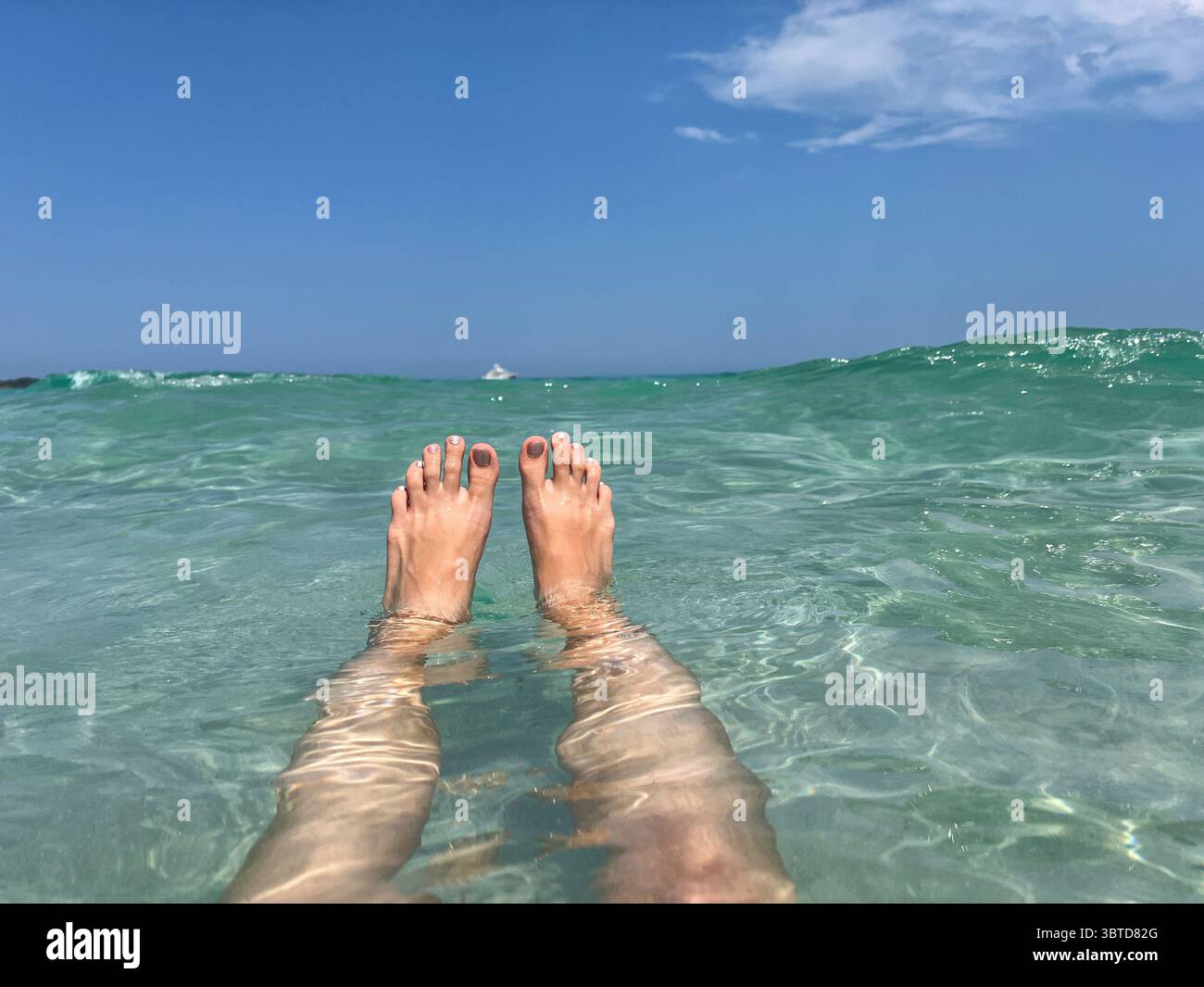 Frauenbeine im Meerwasser. Entspannung, Sommerfreiheit und tropisches Reiseurlaubskonzept. Stockfoto