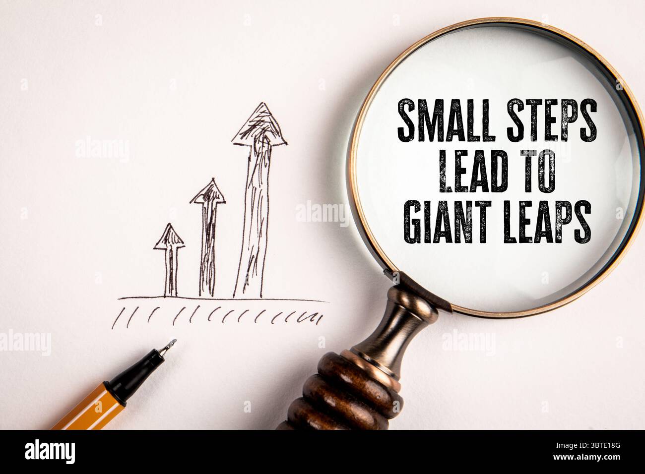 Vergrößerungsglas zur Hervorhebung des Wachstums Botschaft: Kleine Schritte führen zu riesigen Sprüngen. Stockfoto