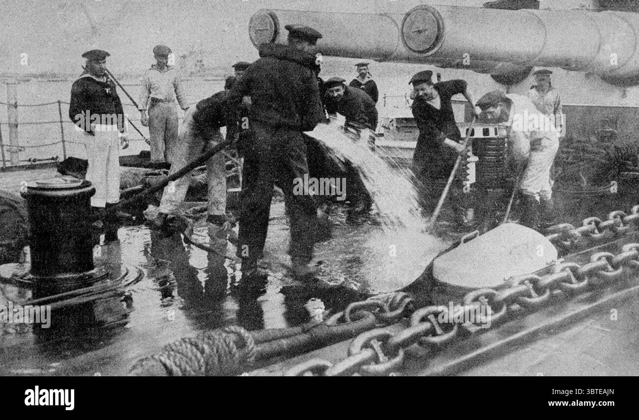 Deutsche Kaiserliche Marine . Deutsche Seeleute waschen die Decks unter den Mündern der großen Geschütze. 1914 Stockfoto
