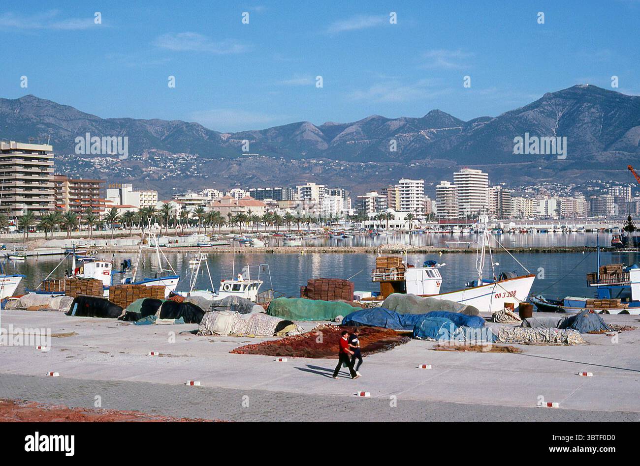 Spanien der 1980er Jahre - Blick auf den Hafen von Fuengirola in Málaga, 1983, mit Fischerbooten, Gebäuden und Bergen Stockfoto