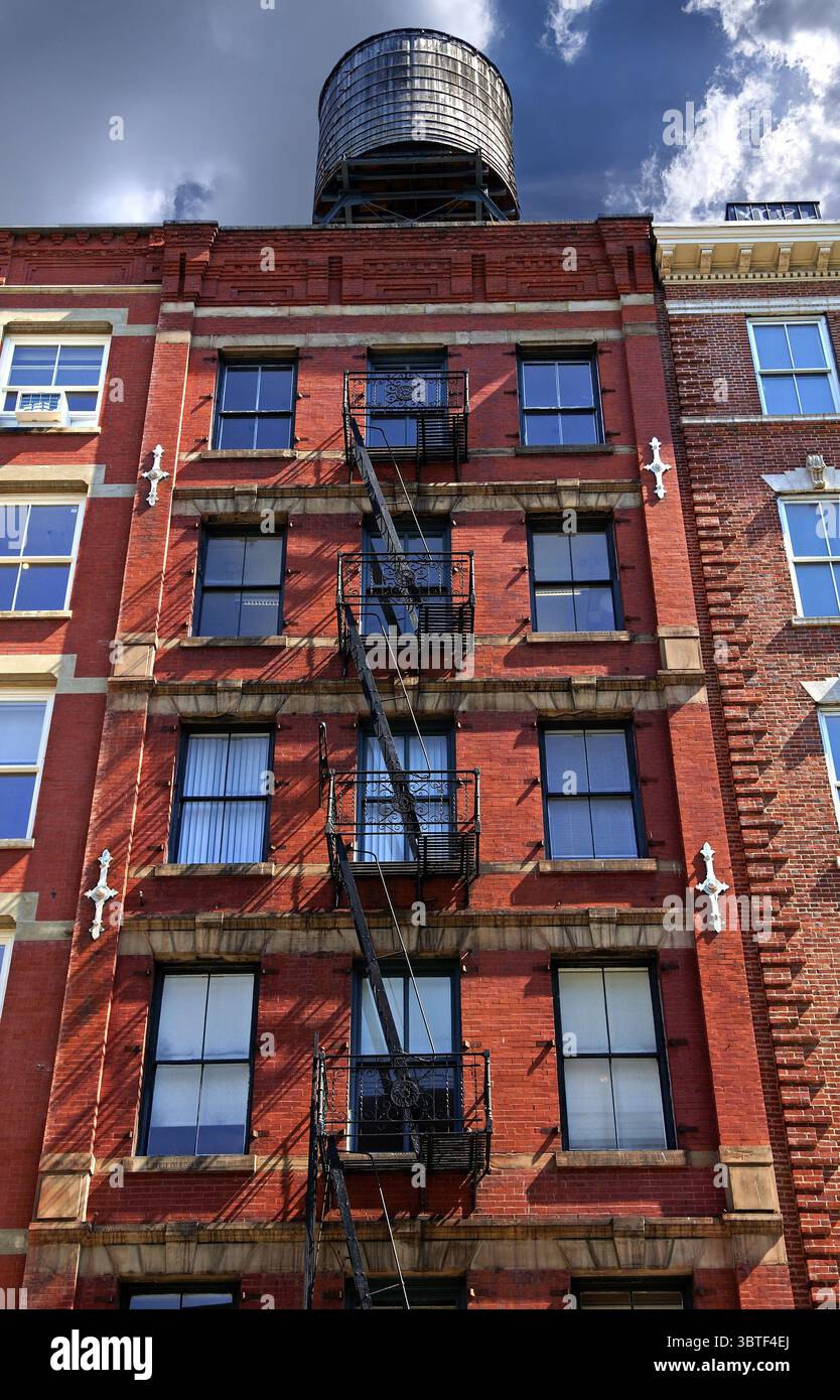 Wohngebäude mit Feuerflüchten und Holzwassertank auf dem Dach, Downtown NY, New York City, USA Stockfoto