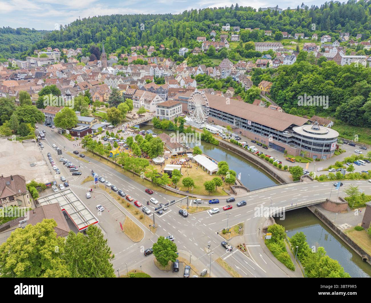 Großer Blick auf eine Stadt mit Fluss und Riesenrad inmitten einer grünen und bergigen Umgebung, 950 Jahre Calw, Calw Parade, Schwarzwald, GE Stockfoto
