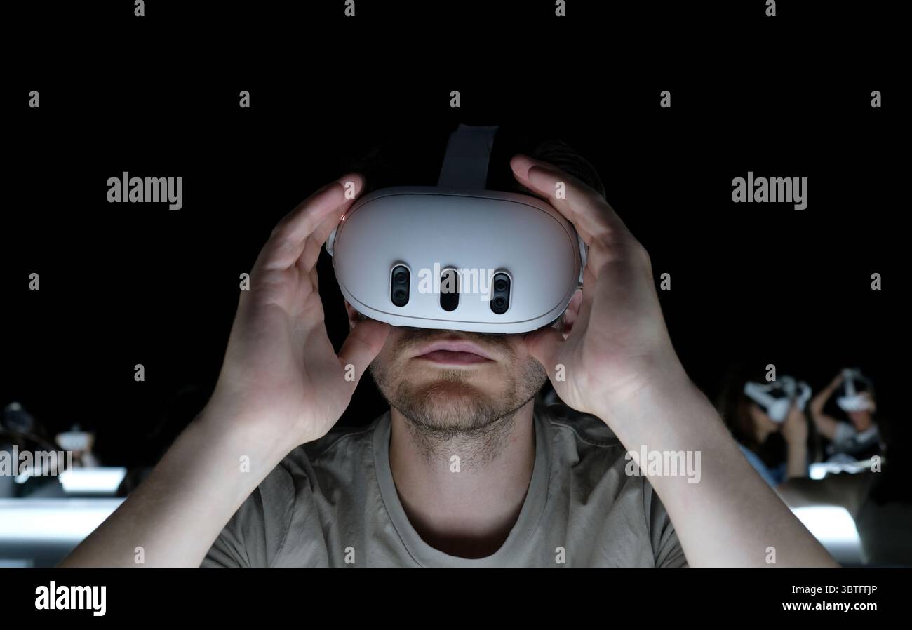 Mann mit Virtual-Reality-Headset in einem dunklen Raum Stockfoto