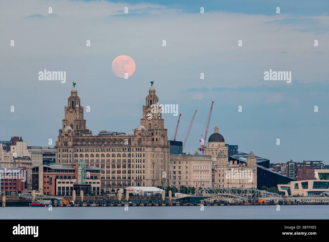 Vollmond, der über dem Liver Building in Liverpool, England aufgeht Stockfoto