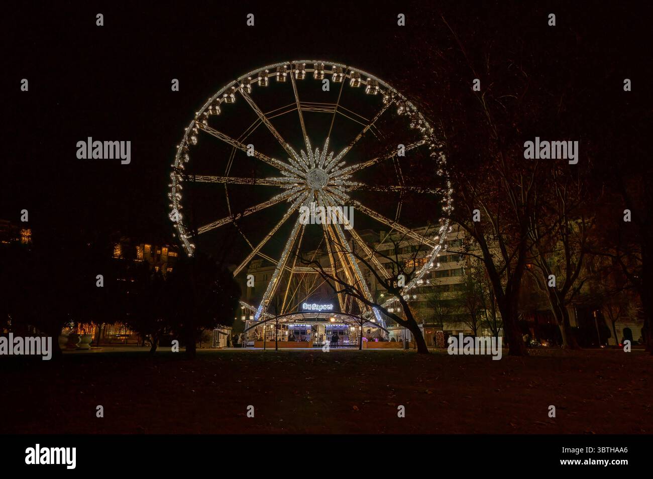 Beleuchtetes Riesenrad, das am Nachthimmel in der Innenstadt von Budapest, Ungarn, März 2025 leuchtet Stockfoto