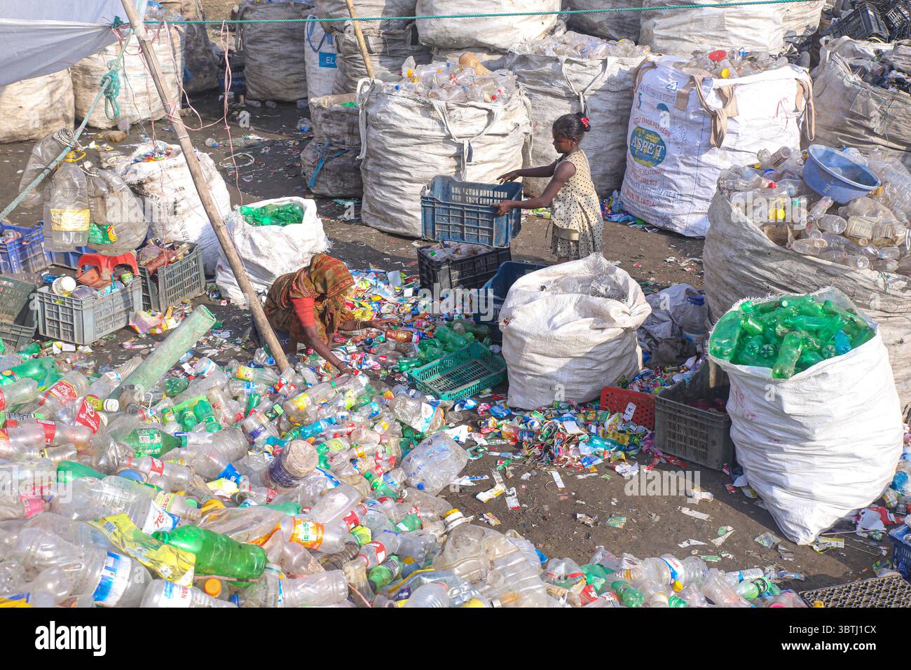 15. Juli 2025, Chittagong, Chittagong, Bangladesch: Arbeiter sortieren in einer Recyclingfabrik in Chittagong gebrauchte Plastikflaschen. Diese Kunststoffflaschen, die häufig zur Verpackung von Trinkwasser verwendet werden, benötigen sehr lange, bis sie vollständig zersetzt sind. Wenn sie verbrannt werden, geben sie giftige Dämpfe in die Umwelt ab. Schwimmende Kunststoffabfälle können viele Jahre im Wasser überleben und dienen oft als winzige Fahrzeuge für invasive Arten, die natürliche Lebensräume bedrohen. Tief im Boden vergraben, können Kunststoffe schädliche Chemikalien freisetzen, die in das Grundwasser gelangen und ernsthafte Risiken für die Umwelt darstellen Stockfoto