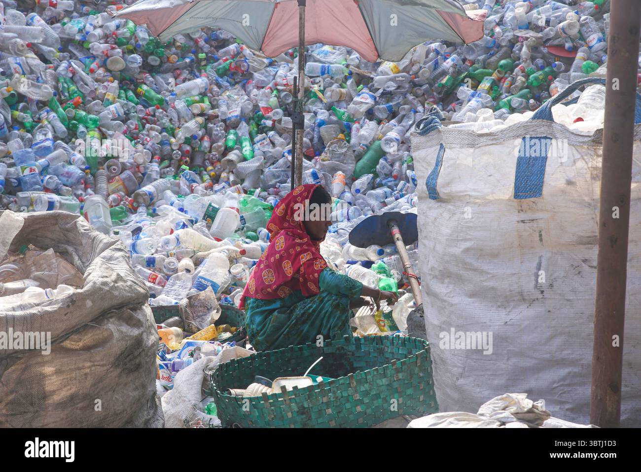 15. Juli 2025, Chittagong, Chittagong, Bangladesch: Arbeiter sortieren in einer Recyclingfabrik in Chittagong gebrauchte Plastikflaschen. Diese Kunststoffflaschen, die häufig zur Verpackung von Trinkwasser verwendet werden, benötigen sehr lange, bis sie vollständig zersetzt sind. Wenn sie verbrannt werden, geben sie giftige Dämpfe in die Umwelt ab. Schwimmende Kunststoffabfälle können viele Jahre im Wasser überleben und dienen oft als winzige Fahrzeuge für invasive Arten, die natürliche Lebensräume bedrohen. Tief im Boden vergraben, können Kunststoffe schädliche Chemikalien freisetzen, die in das Grundwasser gelangen und ernsthafte Risiken für die Umwelt darstellen Stockfoto
