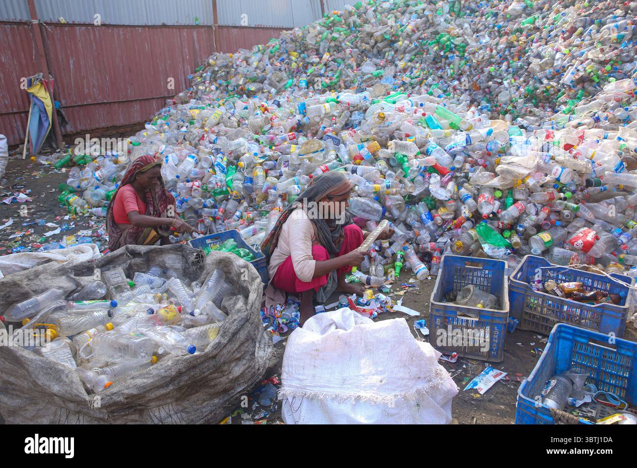 15. Juli 2025, Chittagong, Chittagong, Bangladesch: Arbeiter sortieren in einer Recyclingfabrik in Chittagong gebrauchte Plastikflaschen. Diese Kunststoffflaschen, die häufig zur Verpackung von Trinkwasser verwendet werden, benötigen sehr lange, bis sie vollständig zersetzt sind. Wenn sie verbrannt werden, geben sie giftige Dämpfe in die Umwelt ab. Schwimmende Kunststoffabfälle können viele Jahre im Wasser überleben und dienen oft als winzige Fahrzeuge für invasive Arten, die natürliche Lebensräume bedrohen. Tief im Boden vergraben, können Kunststoffe schädliche Chemikalien freisetzen, die in das Grundwasser gelangen und ernsthafte Risiken für die Umwelt darstellen Stockfoto