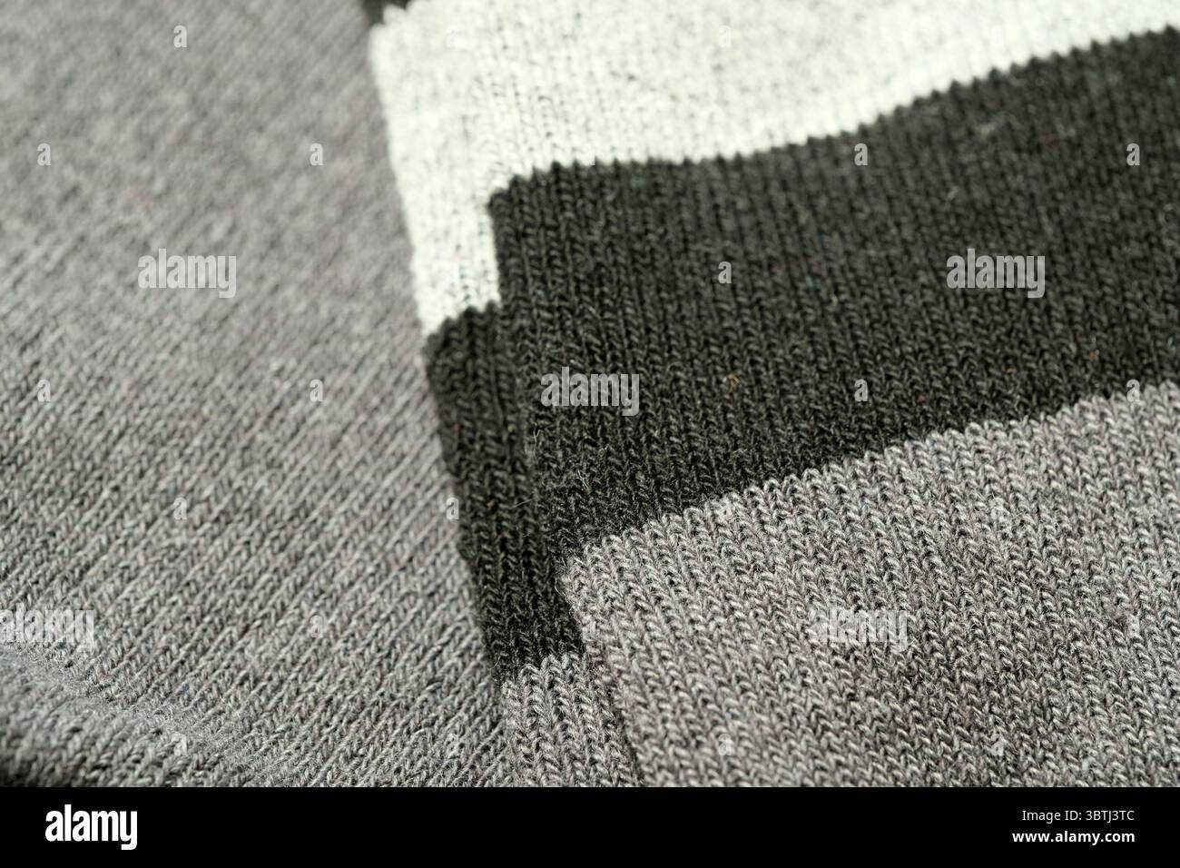 Warmes und einladendes Strickmaterial mit einer Mischung aus Grau- und Grüntönen. Stockfoto