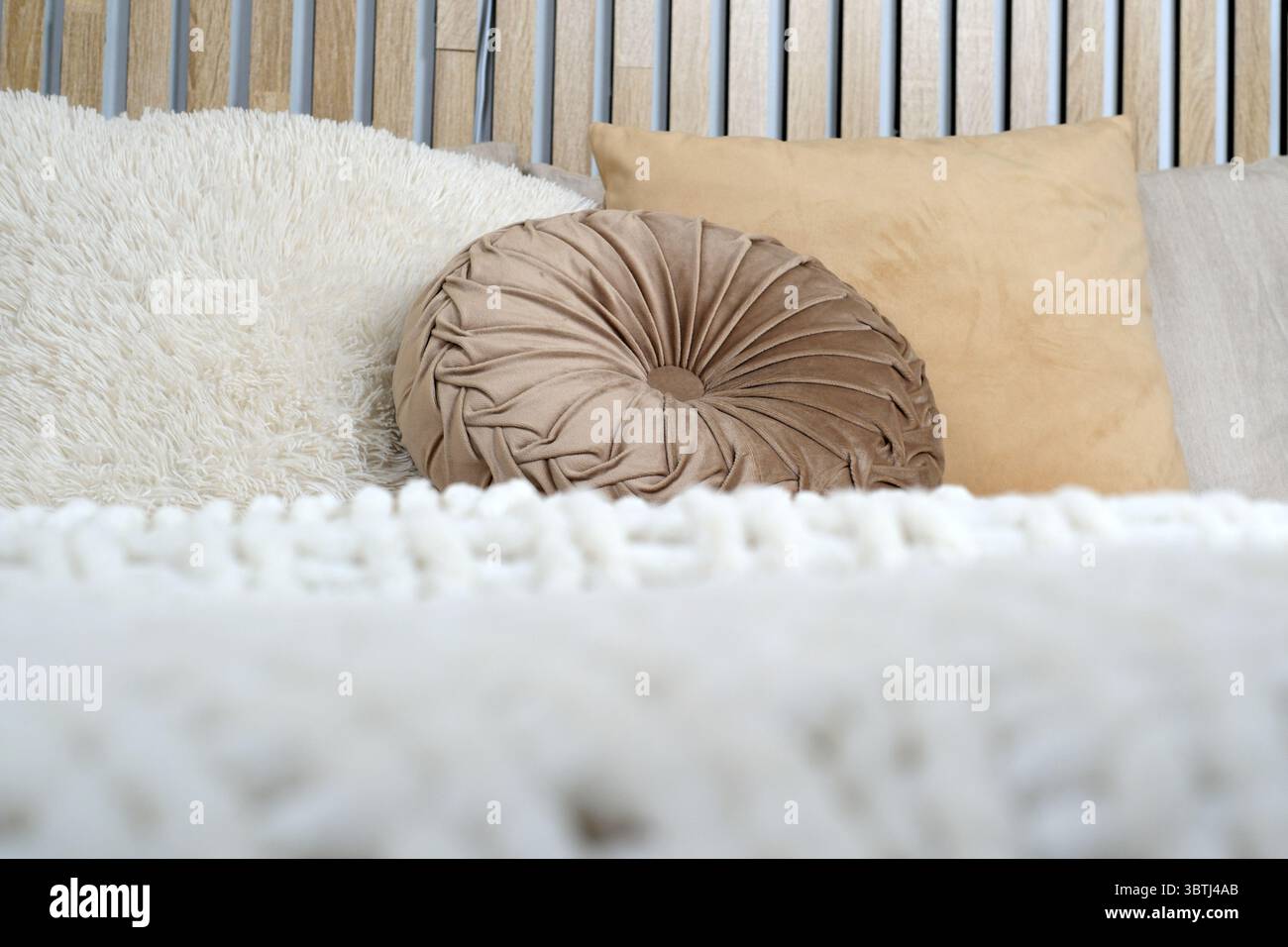 Weiche Kissen und eine flauschige Decke schaffen eine friedliche, einladende Atmosphäre. Stockfoto
