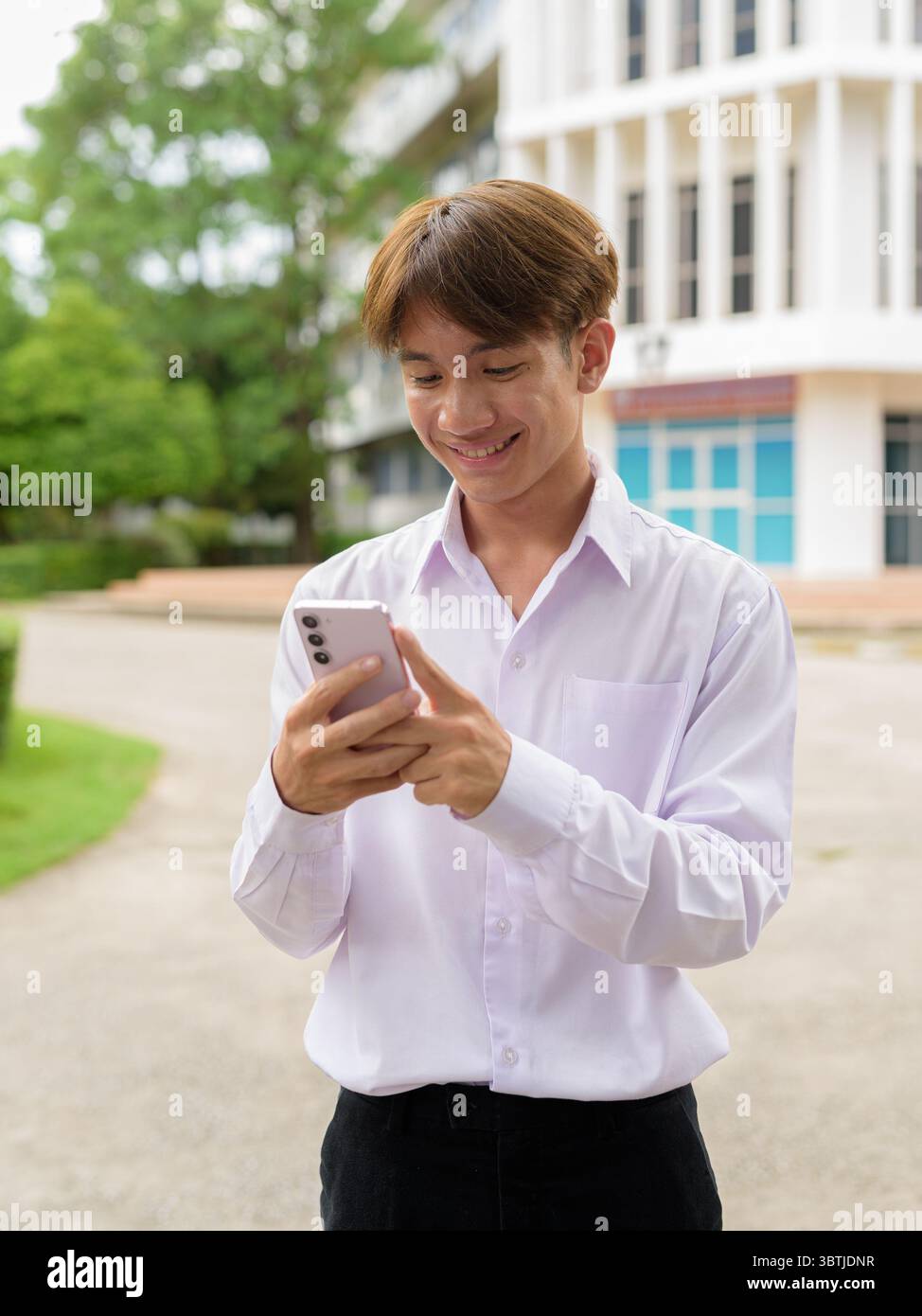 Nicht binäre asiatische Universitätsstudentin auf dem College Campus Stockfoto