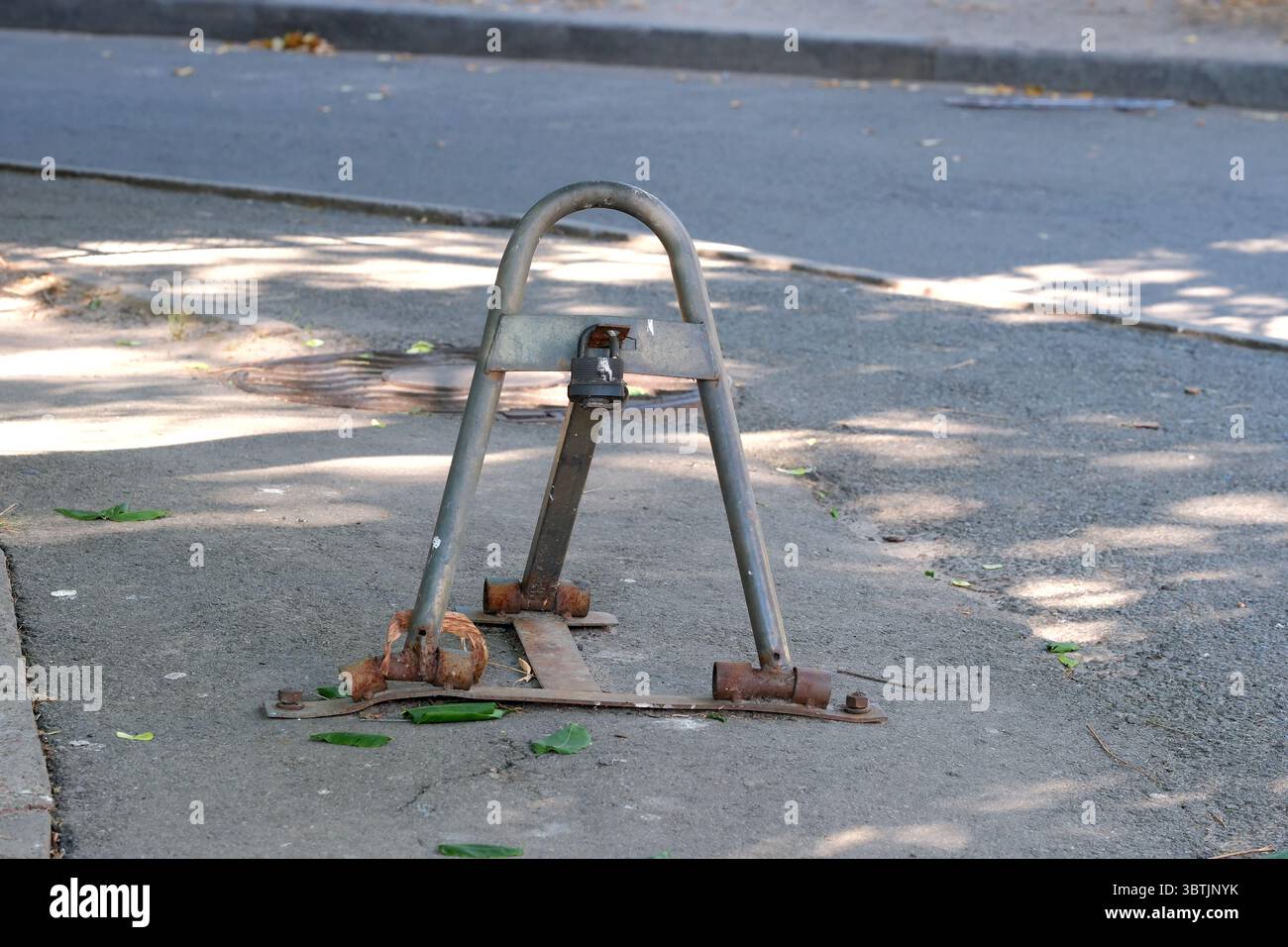 Parksperre auf dem Bürgersteig eines Stadthofes an einem sonnigen Sommertag, Nahaufnahme Stockfoto