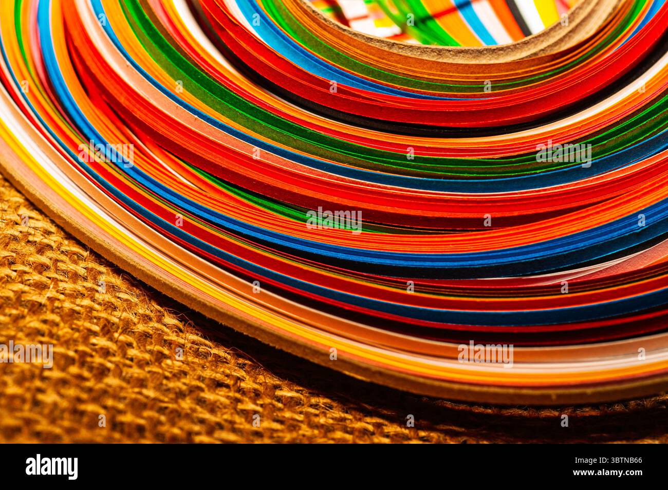 Eine lebendige Nahaufnahme von mehrfarbigen Streifen in fließenden Wellen. Perfekt für abstrakte Hintergründe, kreatives Design oder handwerkliches und farbiges Material Stockfoto