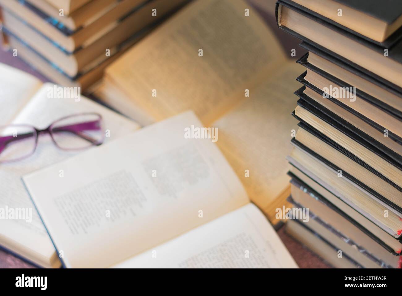 Gemütliche Leseeinrichtung mit Büchern und Brillen Stockfoto