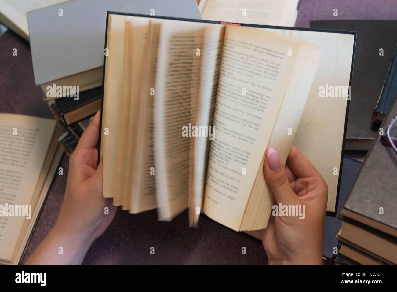 Nahaufnahme der Hände, die Seiten in einem Buch drehen Stockfoto