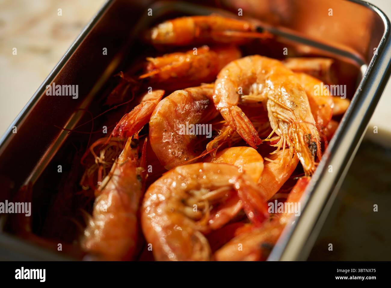 Nahaufnahme von gekochten Garnelen im Edelstahlbehälter Stockfoto