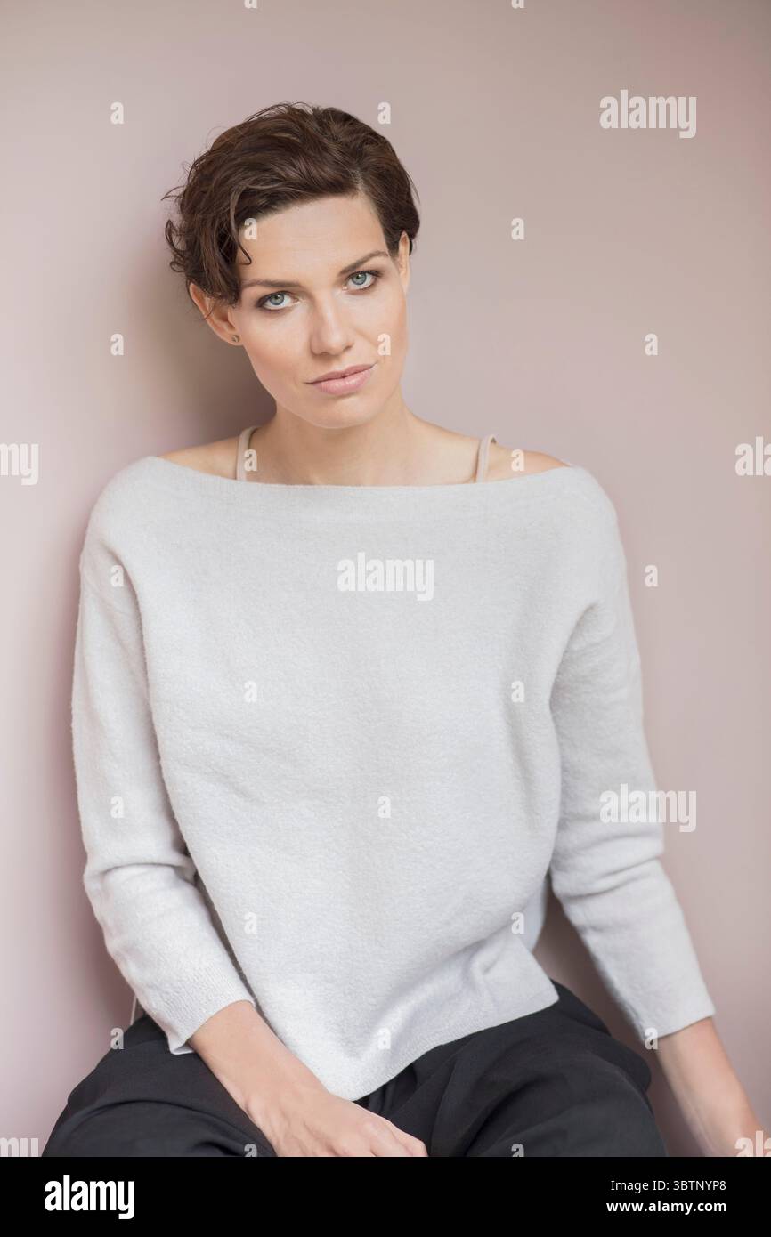 Studio-Porträt einer schönen Frau mit kurzen braunen Haaren, die einen Schulterpullover trägt Stockfoto