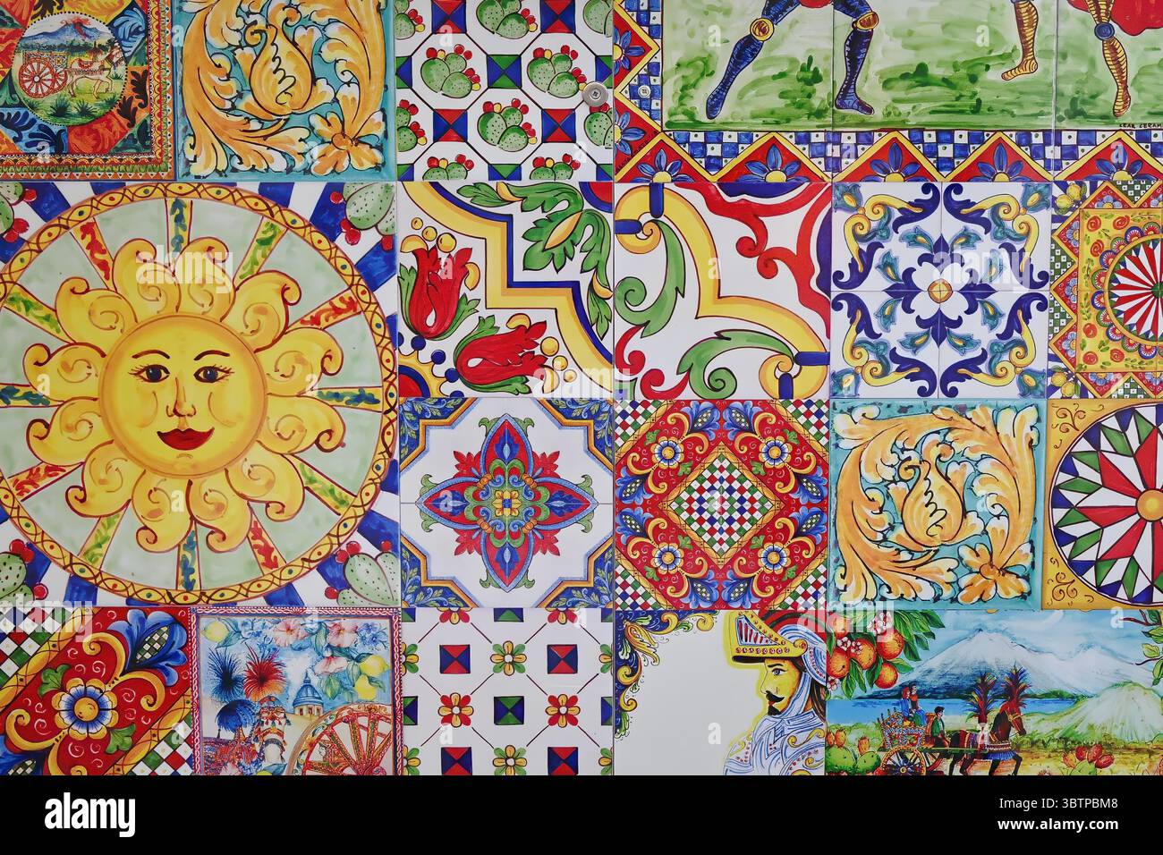 Farbenfrohe sizilianische Keramikfliesen mit traditionellen Motiven wie Sonnenblende, Ritter, Obst, Blumenschmuck und geometrischen Mustern. Stockfoto