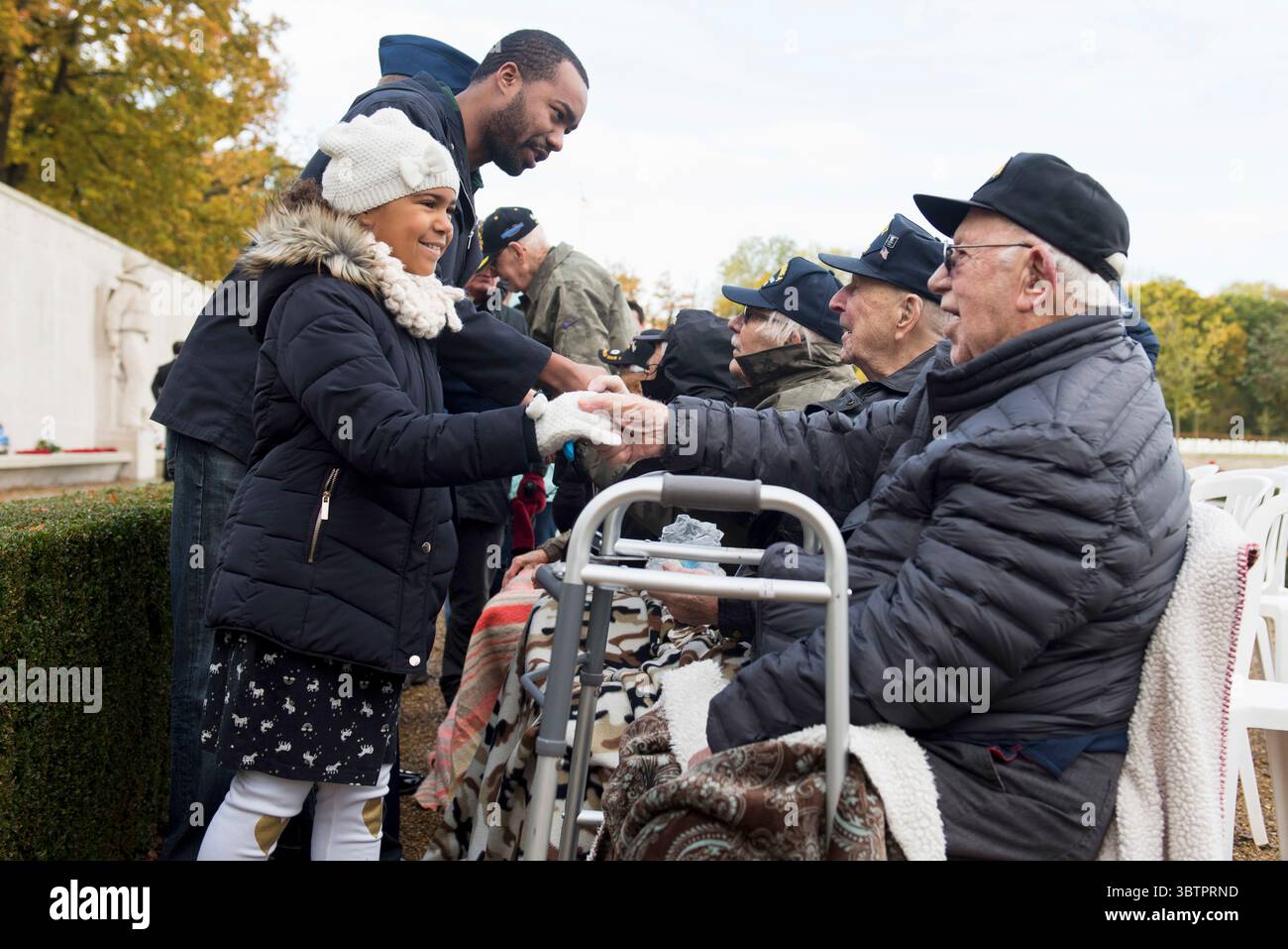 11. November 2019 - Madingley, Cambridgeshire, Vereinigtes Königreich - Tatiyana, Tochter eines lokalen US-Luftwaffenmitglieds, dankt dem Veteranen der US-Armee Frederick Apfelbacker, 2. Armored Division, für seinen Militärdienst während einer Zeremonie zum Veterans Day auf dem Cambridge American Cemetery and Memorial, Madingley, England, 11. November 2019. Die Zeremonie markiert den 101. Jahrestag des Waffenstillstands, der den Ersten Weltkrieg beendete (Bild: © U.S. Air Force/ZUMA Wire/ZUMAPRESS.com) Stockfoto