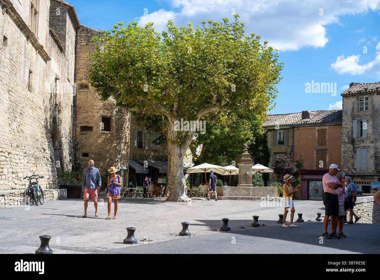 Straßenszene und Abendessen im Restaurant auf dem Stadtplatz von Gordes in Luberon, Teil der Provence, Vaucluse, Südfrankreich Stockfoto