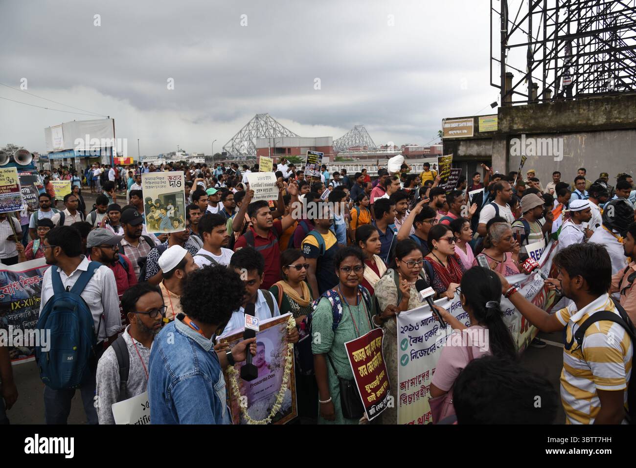 Eine große Anzahl von „berechtigten und unberührten“ Schullehrern, deren Ernennung durch Protest des Obersten Gerichtshofs in Howrah Maidan, wenige Kilometer vor ihrem Ziel, dem Staatssekretariat Nabanna, in Kalkutta, Indien, am 14. Juli 2025 annulliert wurde. Die unter dem Banner des „Sikshak Adhikar Manch“ (Forum für die Rechte der Lehrer) organisierten Agitatoren drängten und schoben gegen eine vom Personal in Uniform eingerichtete menschliche Barrikade, was zu Spannungen am Boden führte, nachdem die Demonstranten unbeirrt das Sekretariat erreichten und mit ihren Forderungen auf Premierminister Mamata Banerjee trafen. (Foto von Stockfoto Eine große Anzahl von „berechtigten und unberührten“ Schullehrern, deren Ernennung durch Protest des Obersten Gerichtshofs in Howrah Maidan, wenige Kilometer vor ihrem Ziel, dem Staatssekretariat Nabanna, in Kalkutta, Indien, am 14. Juli 2025 annulliert wurde. Die unter dem Banner des „Sikshak Adhikar Manch“ (Forum für die Rechte der Lehrer) organisierten Agitatoren drängten und schoben gegen eine vom Personal in Uniform eingerichtete menschliche Barrikade, was zu Spannungen am Boden führte, nachdem die Demonstranten unbeirrt das Sekretariat erreichten und mit ihren Forderungen auf Premierminister Mamata Banerjee trafen. (Foto von Stockfoto