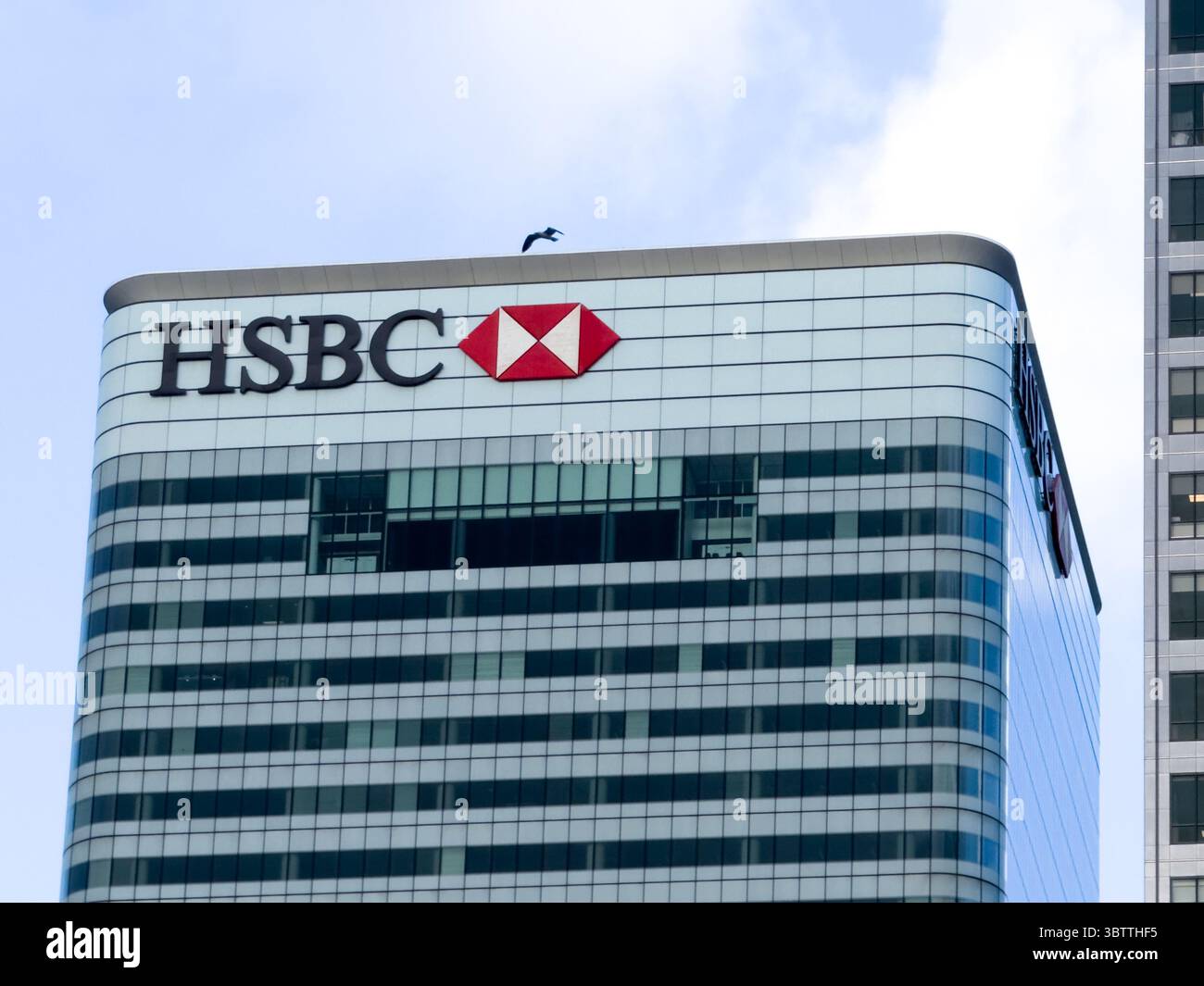Das HSBC-Logo befindet sich oben auf dem Hauptquartier im Finanzdistrikt Canary Wharf, London, Großbritannien Stockfoto