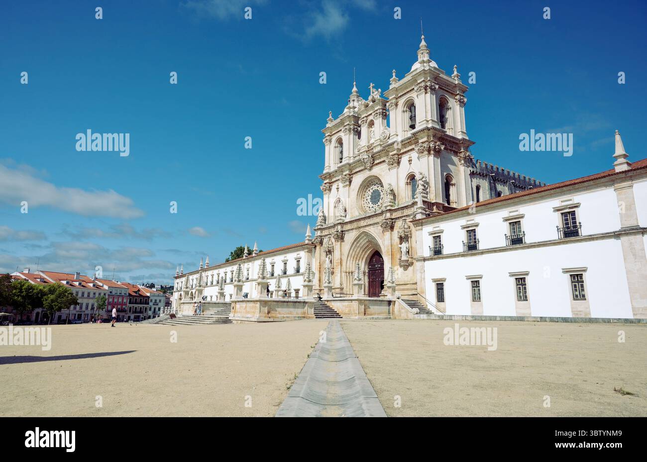 Die große Fassade des Klosters von Alcobaca steht unter einem strahlend blauen Himmel Stockfoto