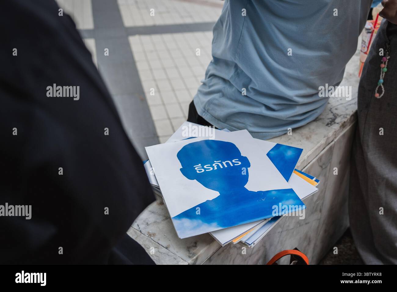 Während der Mahnwache „Volksamnestie“ liegt ein Stapel von Plakaten mit den Namen von Aktivisten auf einer Marmorbank. Vor dem Kunst- und Kulturzentrum von Bangkok versammelten sich die Menschen zu einer Mahnwache mit dem Titel „Light Up Hope for the People's Amnesty“. Im Vorfeld einer parlamentarischen Debatte am 16. Juli 2025 wurden persönliche Zeugenaussagen, Porträts von 50 politischen Häftlingen und eine rote Rose mit der Aufschrift „Amnesty 112“ präsentiert. Die Teilnehmer forderten die Verabschiedung eines umfassenden Amnestiegesetzes für Fälle gemäß Abschnitt 112 des thailändischen Strafgesetzbuches. Stockfoto
