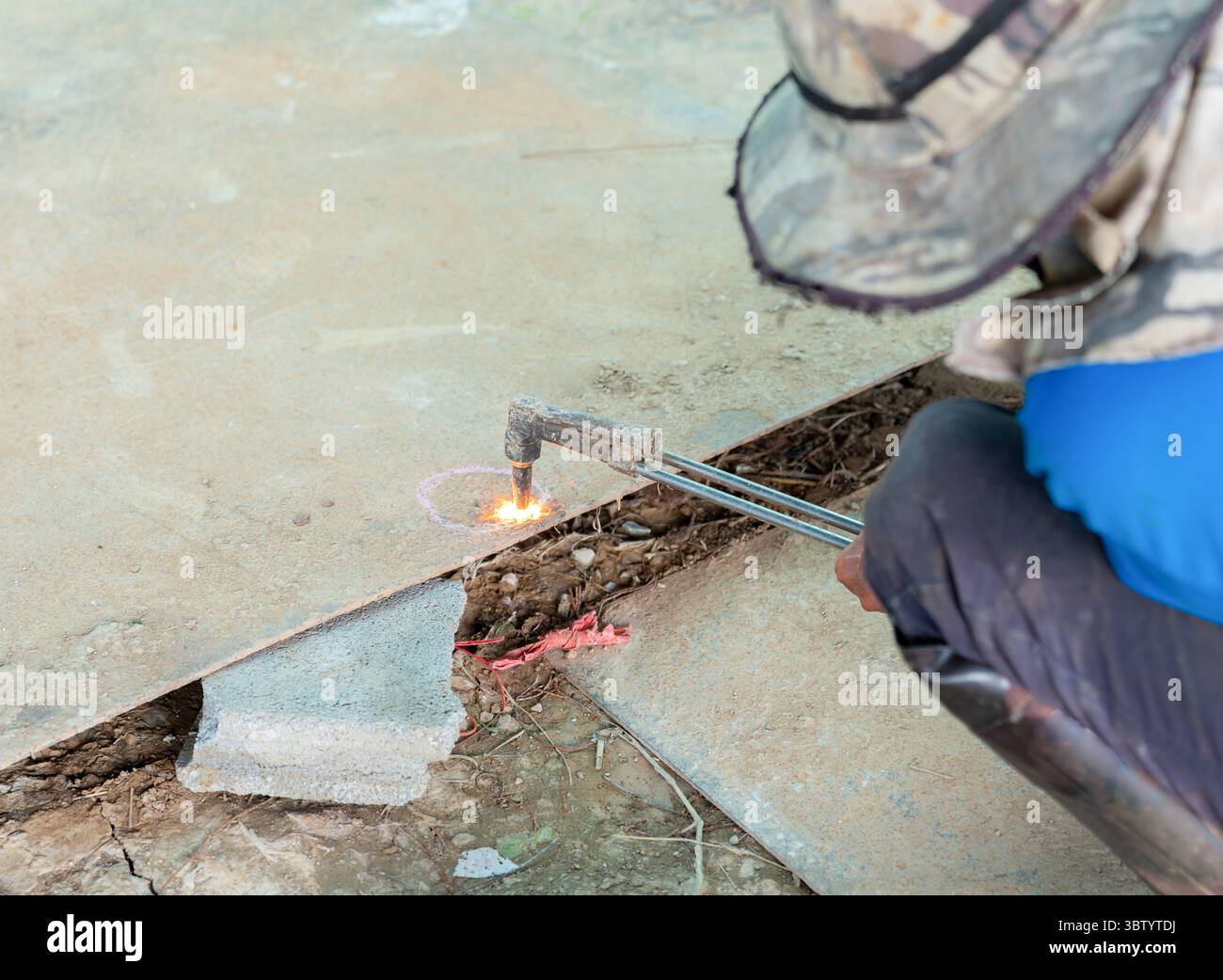 Der Arbeiter schneidet Sauerstoff-Acetylen-Gas auf einem Stahlblech. Stockfoto