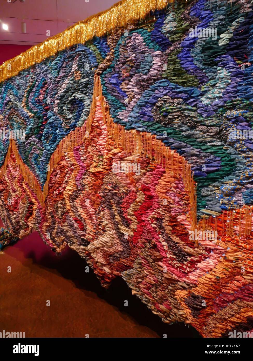 SEATTLE - 23. APR 2025 - Ein großer, farbenfroher Wandteppich hängt in einem Museum, dessen leuchtende Farbtöne den Raum beleuchten und die Zuschauer mit seiner faszinierenden Schönheit verzaubern Stockfoto