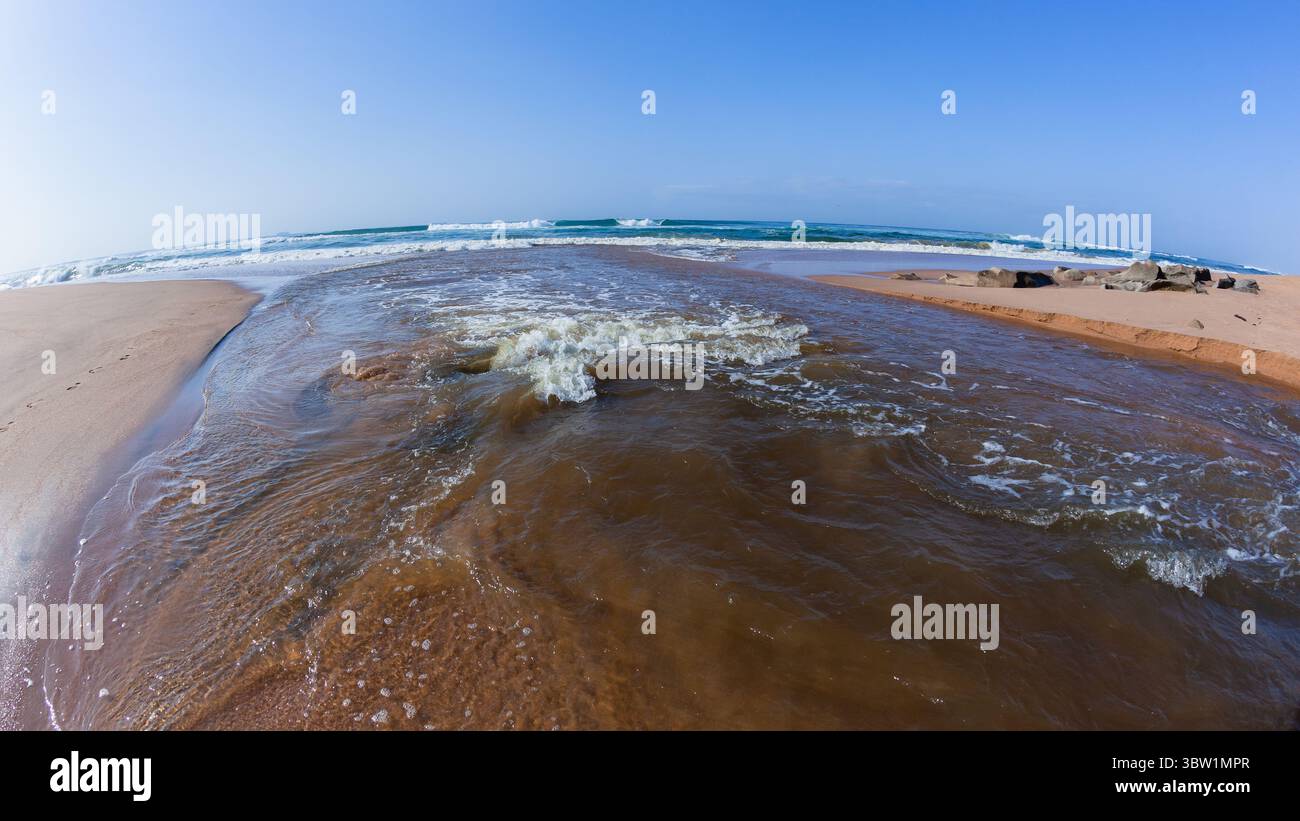Rivermouth fließendes Wasser mittleres Foto aus der Lagune durch Strand Sandbar zum blauen Himmel Ozean. Stockfoto