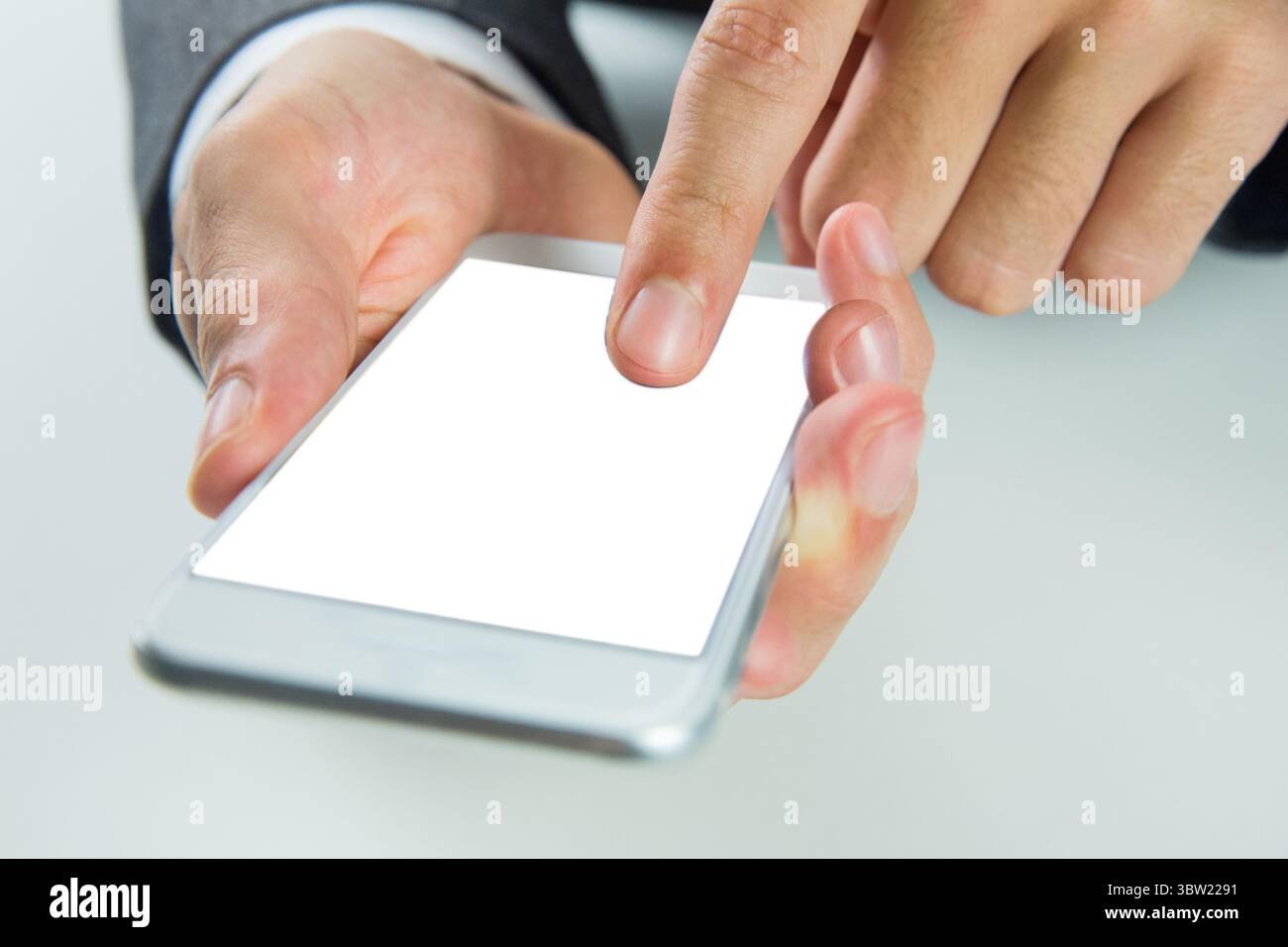 Geschäftsmann klopft in der flachen Büroszene auf ein leeres Smartphone und hebt gepflegte Hände hervor Stockfoto