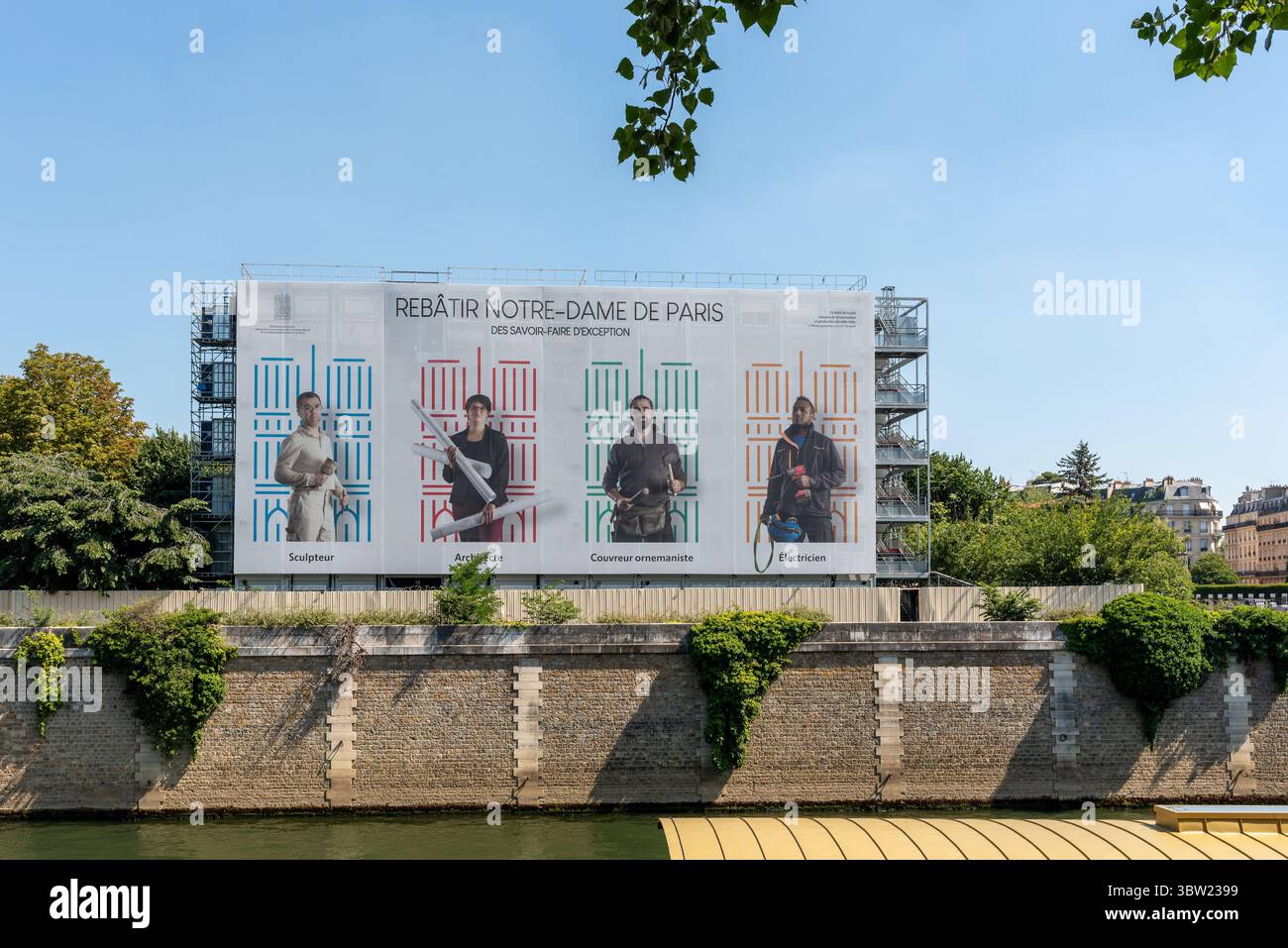 Eine riesige Plakatwand in der Nähe der Notre Dame: „Wiederaufbau der Notre Dame“ und zeigt die Art der beteiligten Personen: Bildhauer, Architekt, Roofer, Elektriker Stockfoto