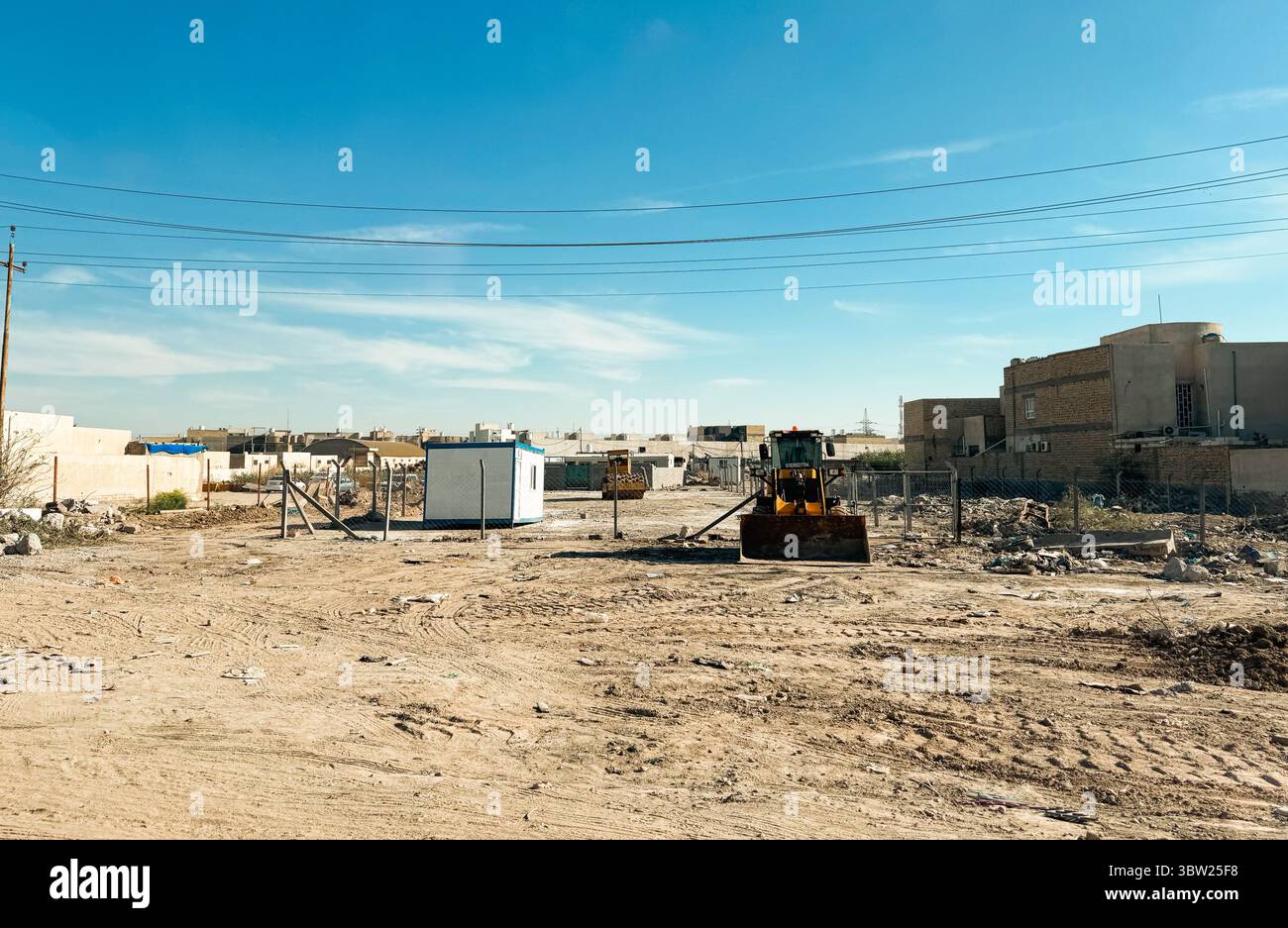 Eine Baustelle in einem Najaf Irak verfügt über schwere Maschinen, temporäre Bauten und einen klaren blauen Himmel. Stockfoto