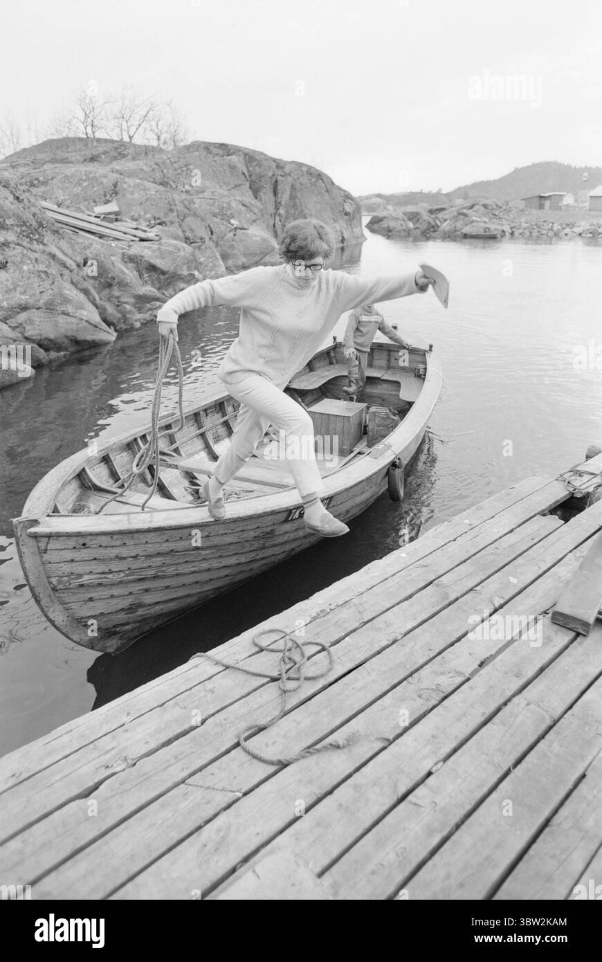 Aktuell 20-2-1969 : Mutter macht ihre Artium-Prüfung. Aslaug Kristensen, Mutter von sieben Kindern, macht derzeit ihre Artium-Prüfung, um einen alten Traum zu verwirklichen. - Das Mädchen, das vom Motorboot an Land springt, ist die Mutter von sieben Jahren und hat im Frühjahr ein paar Artiumprüfungen absolviert. Neben dem Studium für ihre Artium Examen ist sie unter anderem Hausfrau und Radfahrerin für Zeitungslieferanten. Jeden Tag bringt sie 25 Zeitungen zu den verschiedenen Abonnenten. Foto; per Ervik / aktuell / NTB ***FOTO NICHT VERARBEITET*** *Text wird automatisch übersetzt* Stockfoto