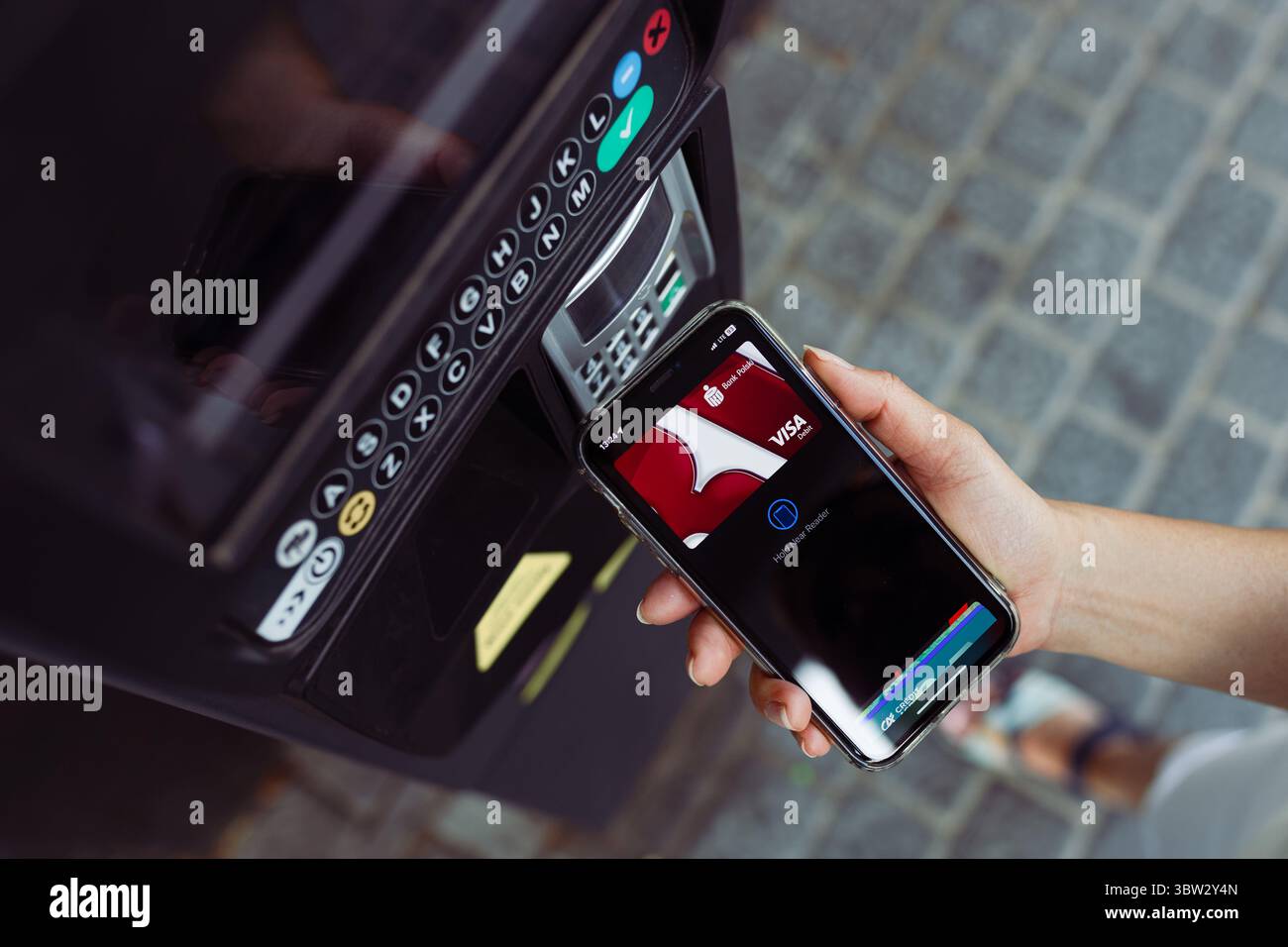 Lublin, Polen - 13.07.2025. Frau, die die Parkkarte mit der Bank Polski Debitkarte in der mobilen Geldbörse bezahlt. Elektronische Zahlungen. NFC-Technologie Stockfoto