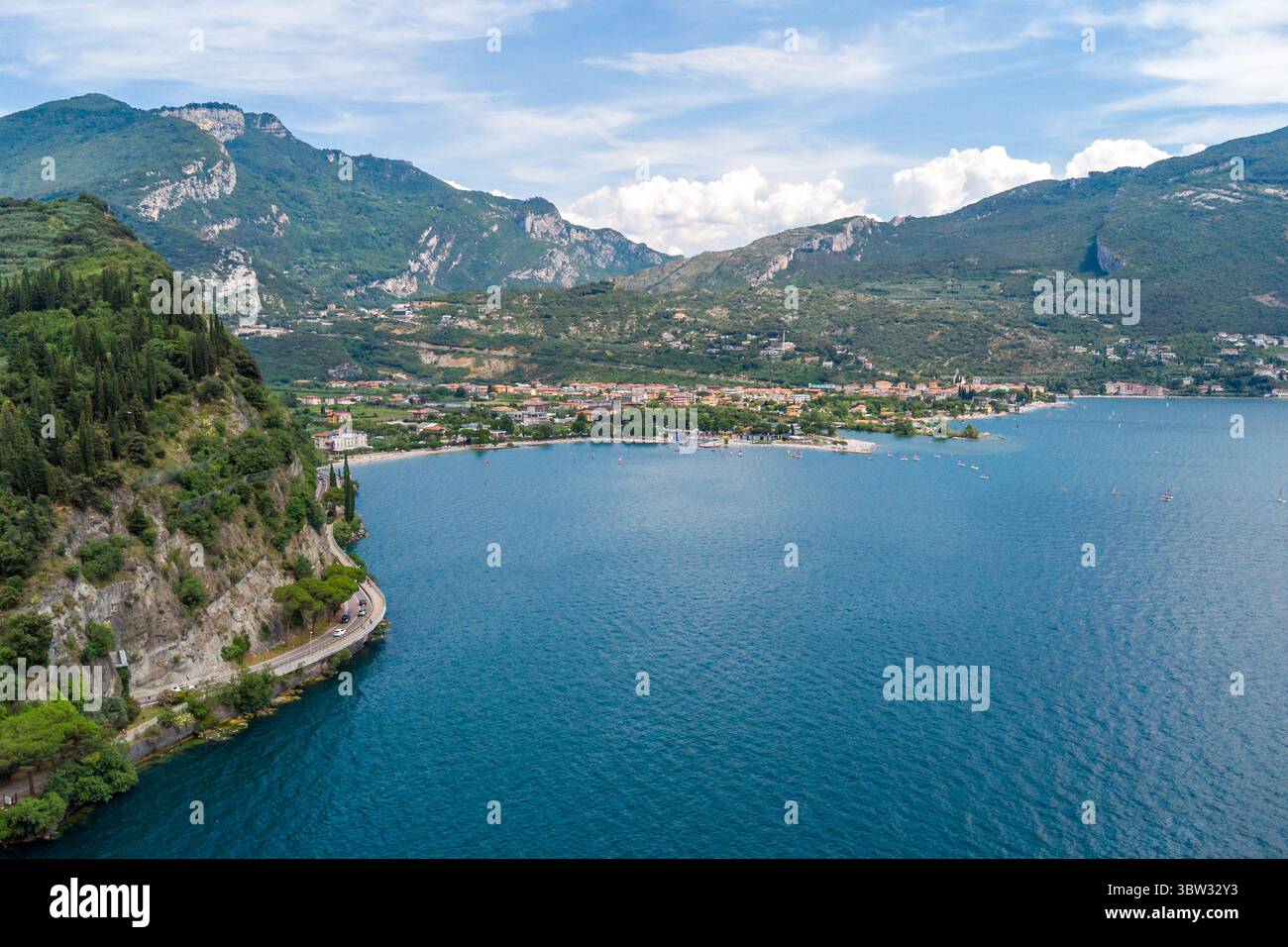 Torbole, Gardasee, Italien - 15. Juli 2025: Weitläufiger Blick über den Gardasee in Norditalien - der größte See des Landes ist von steilen Berghängen und türkisfarbenem Wasser umgeben. *** Weitläufige Drohnenansicht über den Gardasee in Norditalien der größten See des Landes zeigt sich umgeben von steilen Berghängen, türkisfarbenem Wasser. Stockfoto