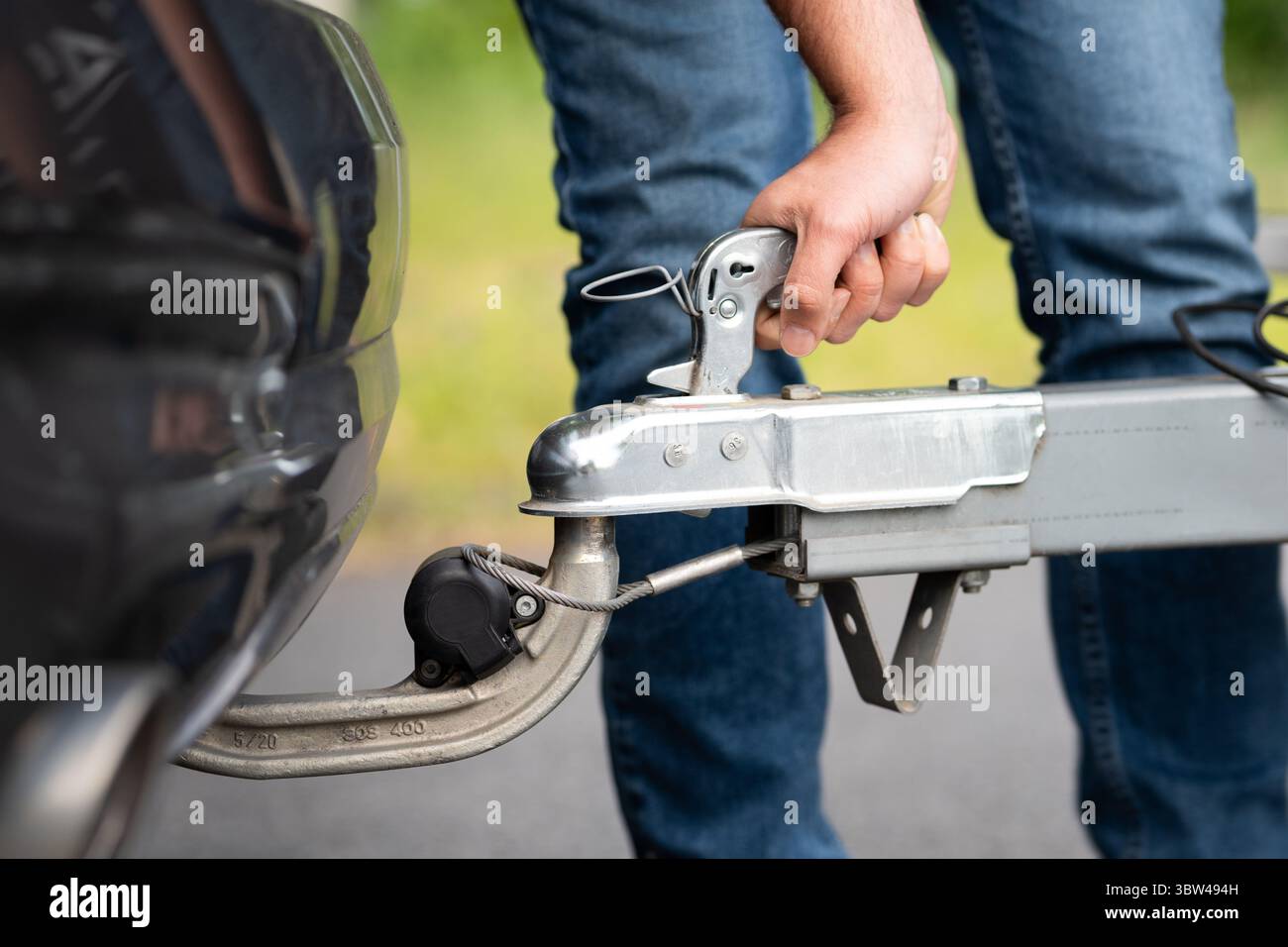 Befestigen Sie einen Anhänger in Nahaufnahme am Fahrzeug. Verriegeln des Hebels der Kraftheberkupplung zur Verbindung mit der Kupplungskugel. Verwendung des Abschlepphakens unter dem Stoßfänger. Stockfoto