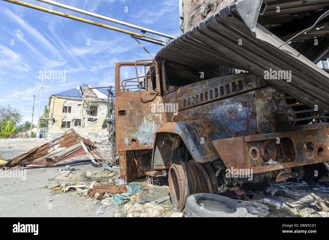 Verbrannter militärischer Panzerwagen auf der Straße des zerstörten Stadtkrieges Ukraine Russland Stockfoto